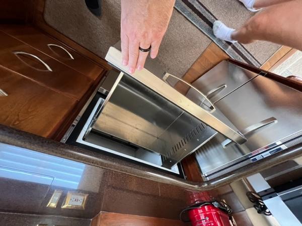Man opening refrigerator in 2009 Ovation 52 yacht kitchen.