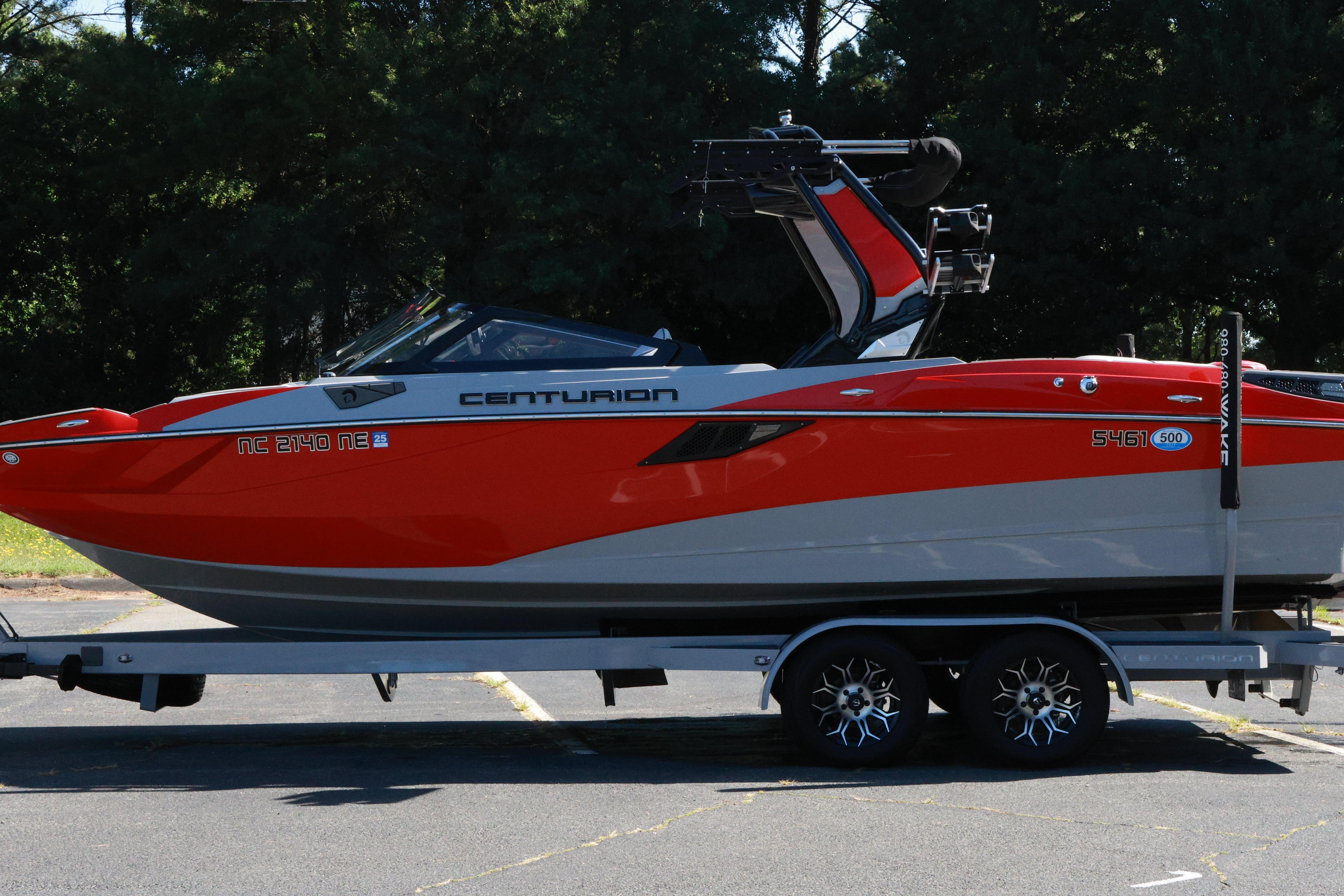 2024 Centurion Fi23 boat on trailer, vibrant red and gray design.