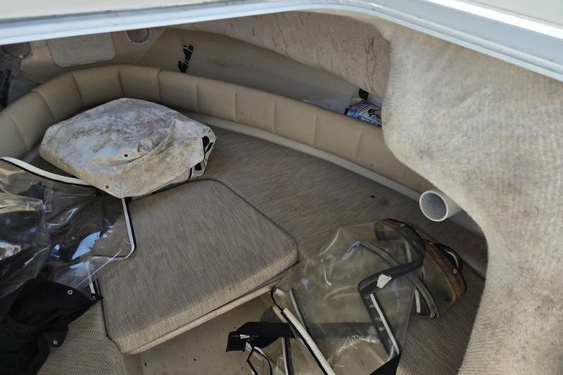 2004 Robalo R235 Walkaround cabin interior with seating and storage items.