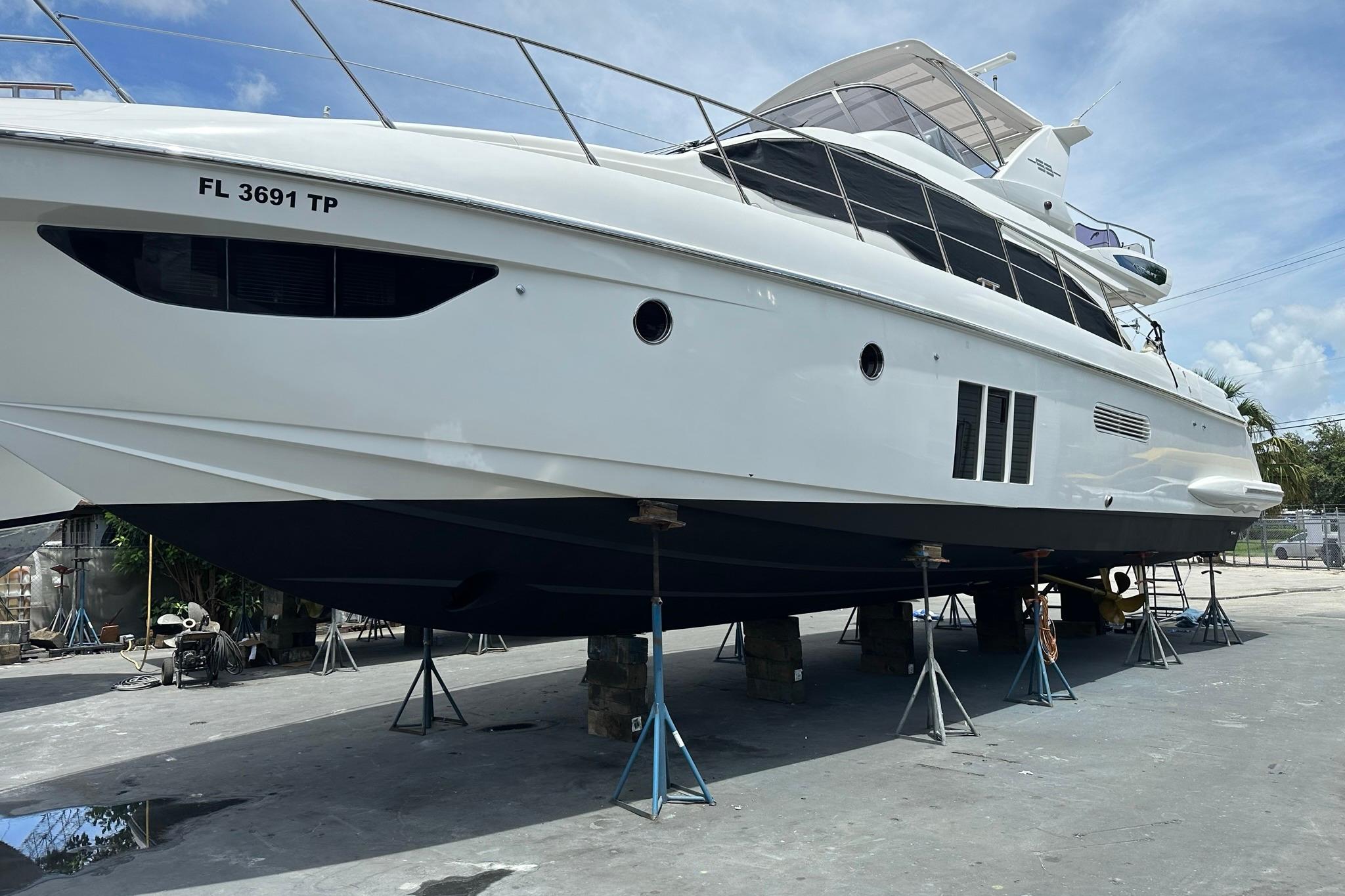 2013 Azimut Fly 53 yacht on stands, side view, clear sky background.