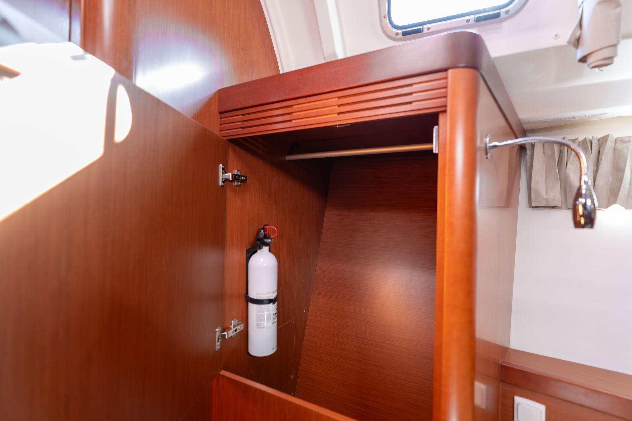 2013 Beneteau Oceanis 50 interior closet with fire extinguisher and wooden finish.