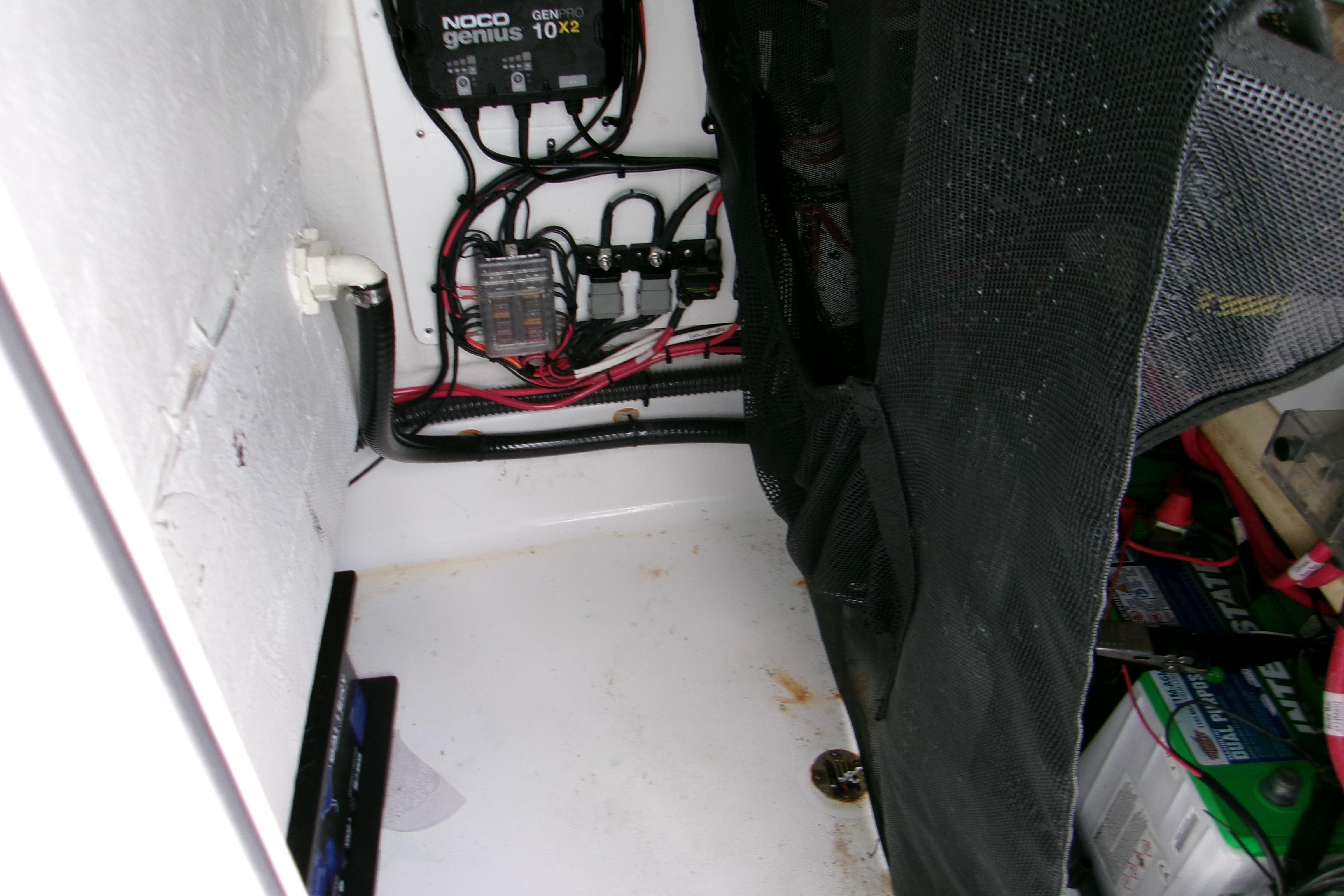 Electrical compartment of 2024 Sportsman Masters 227 Bay Boat with wiring and battery charger.