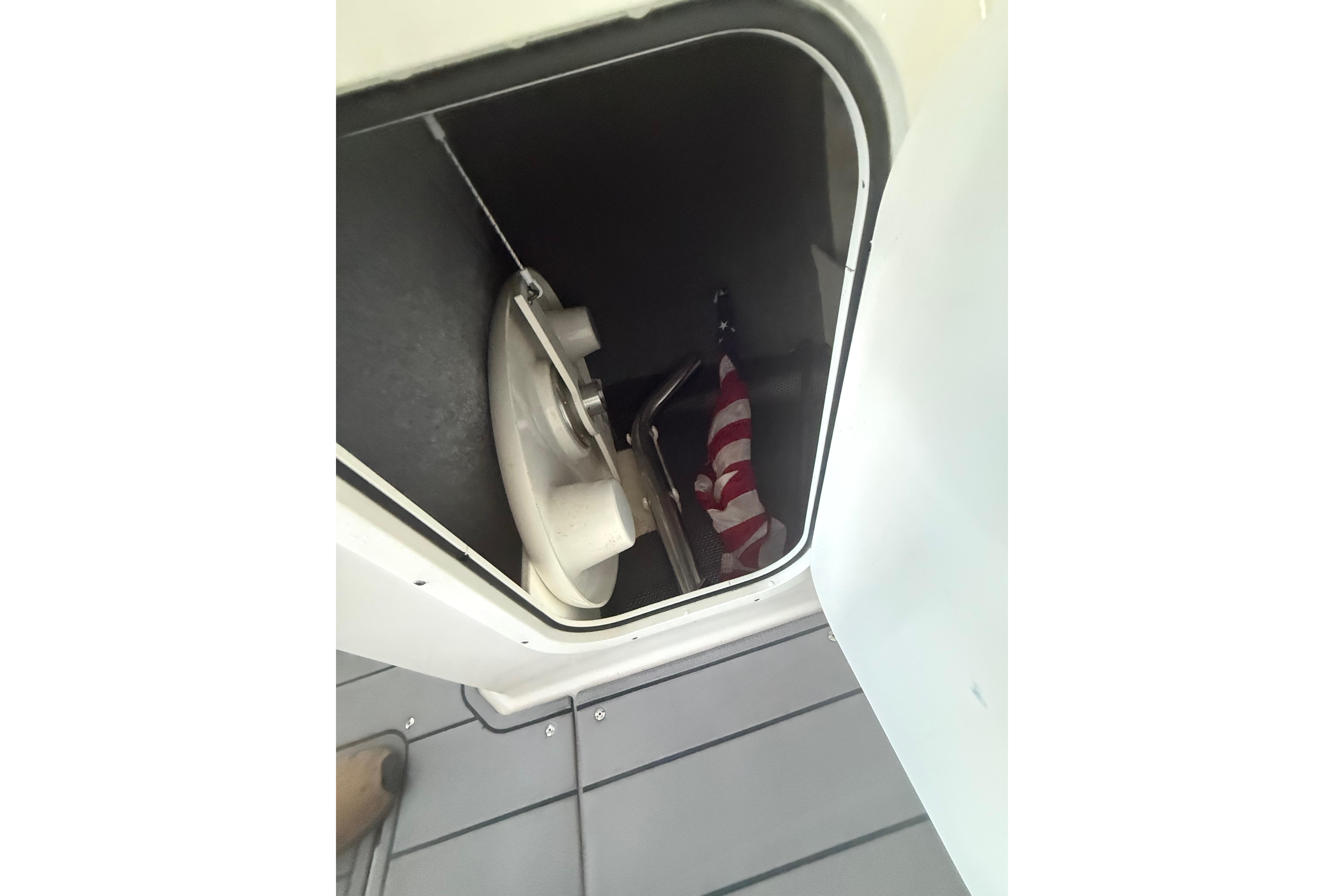 Storage compartment in 2023 Chaparral 230 SSi boat with American flag inside.