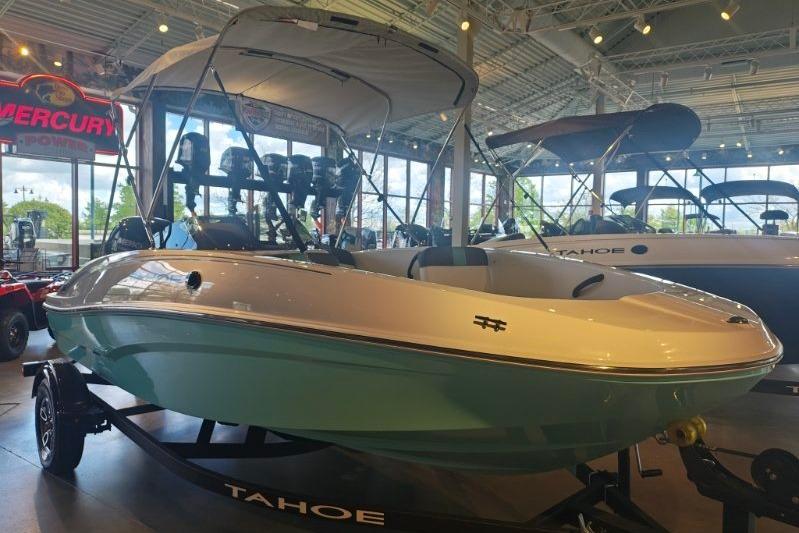 2026 Tahoe T16 boat displayed in a showroom with canopy and trailer.