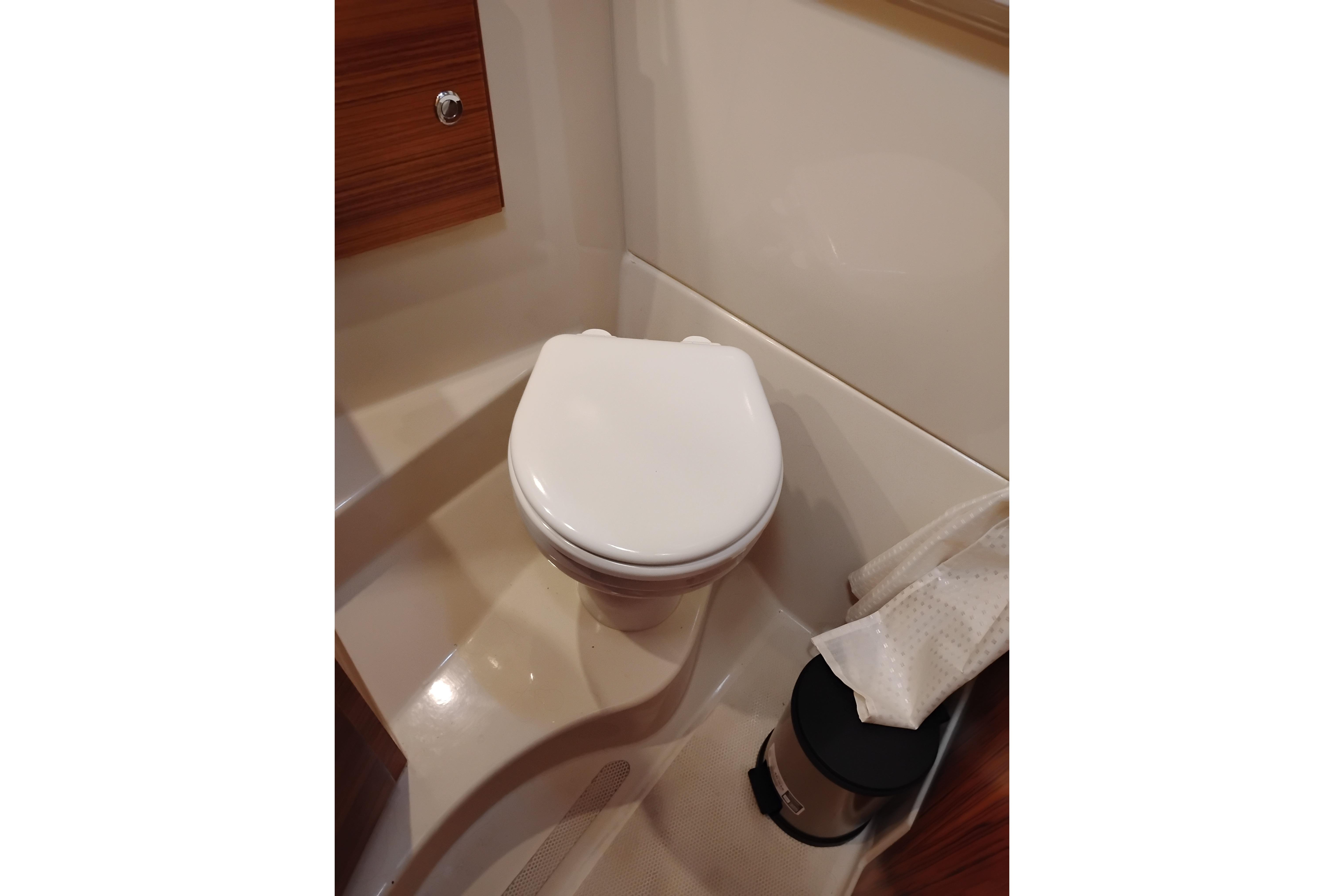 2024 Ranger Tugs R-27 boat bathroom with compact toilet and waste bin.