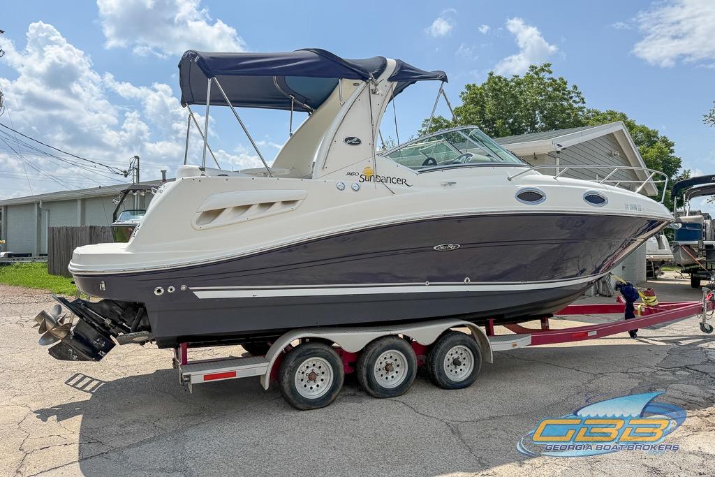 2006 Sea Ray Sundancer 260 boat on trailer, parked outdoors under a clear sky.