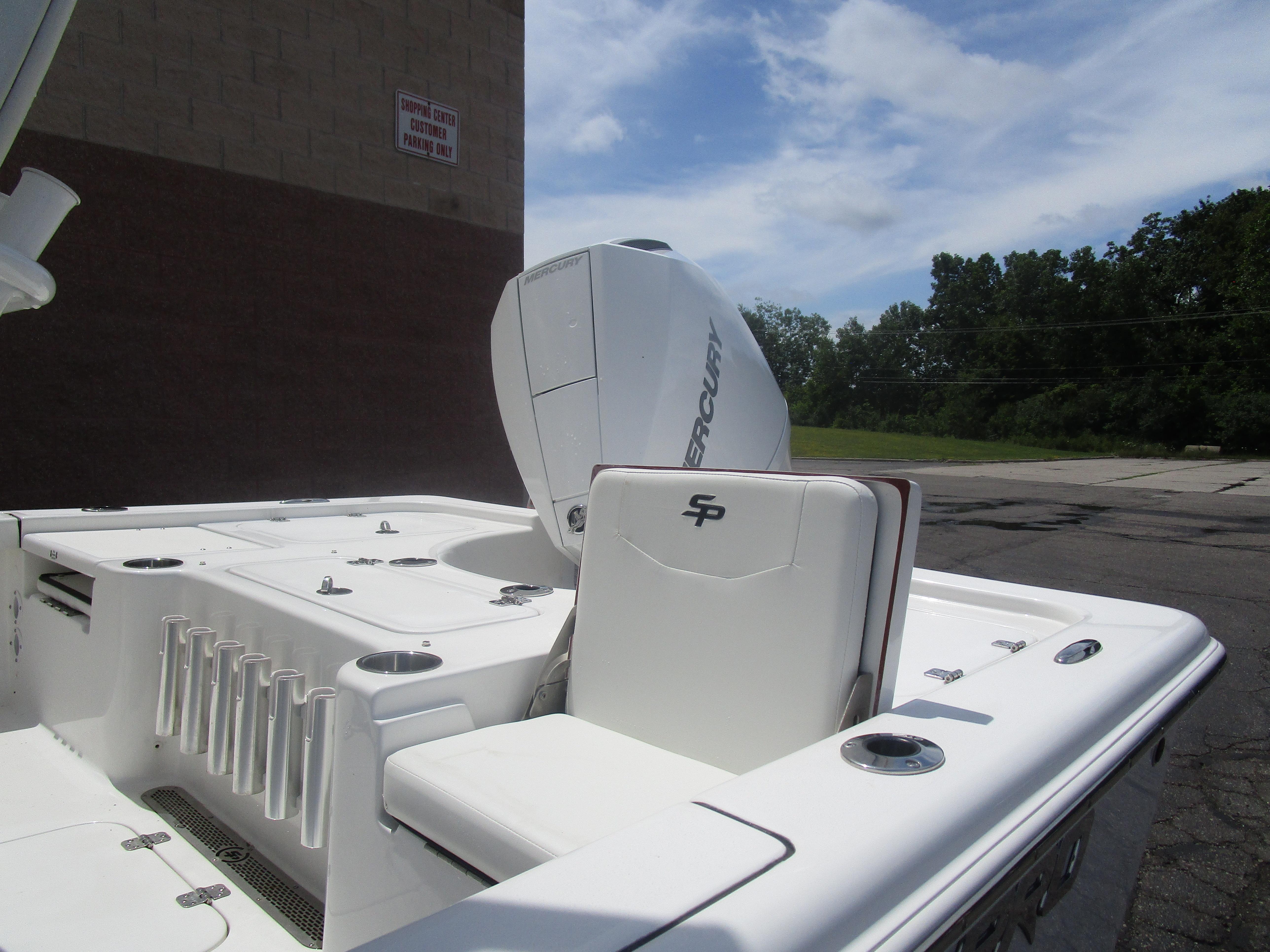 2025 Sea Pro 230 DLX BAY boat with Mercury engine, white interior, and rod holders.