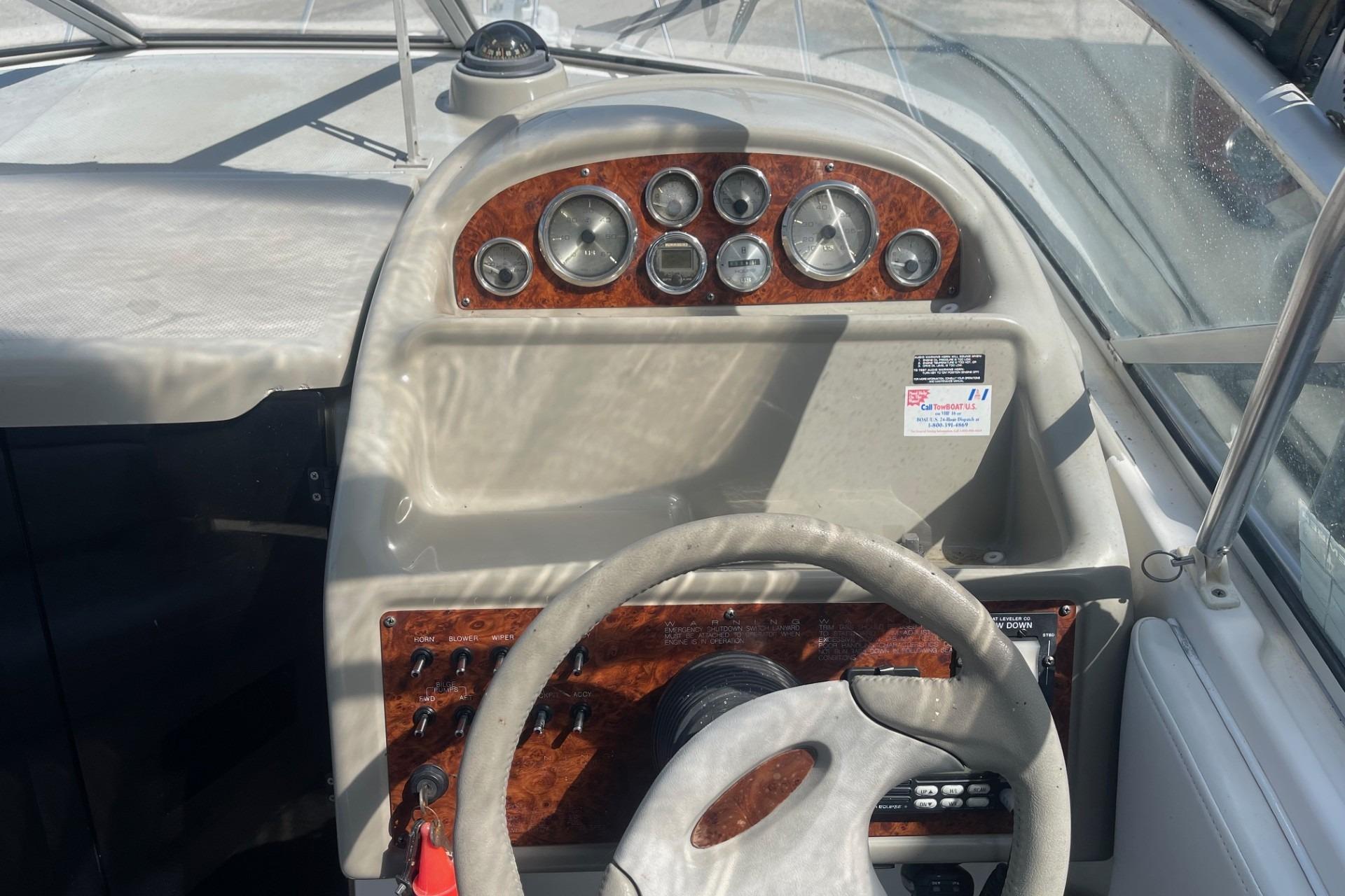 1997 Bayliner 2655 Ciera boat dashboard with gauges and steering wheel.
