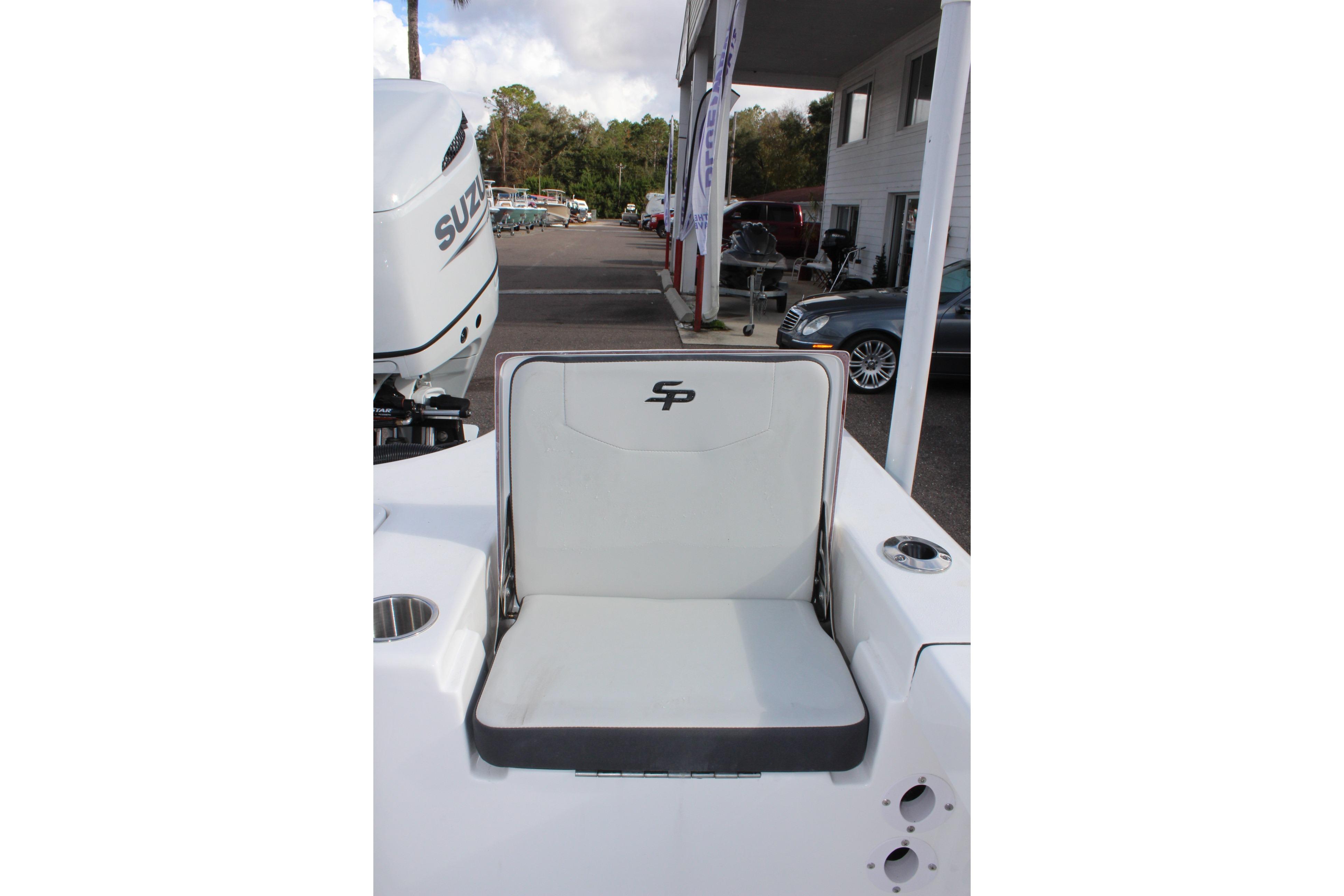 2025 Sea Pro 230 Bay boat seat with Suzuki engine in dealership setting.