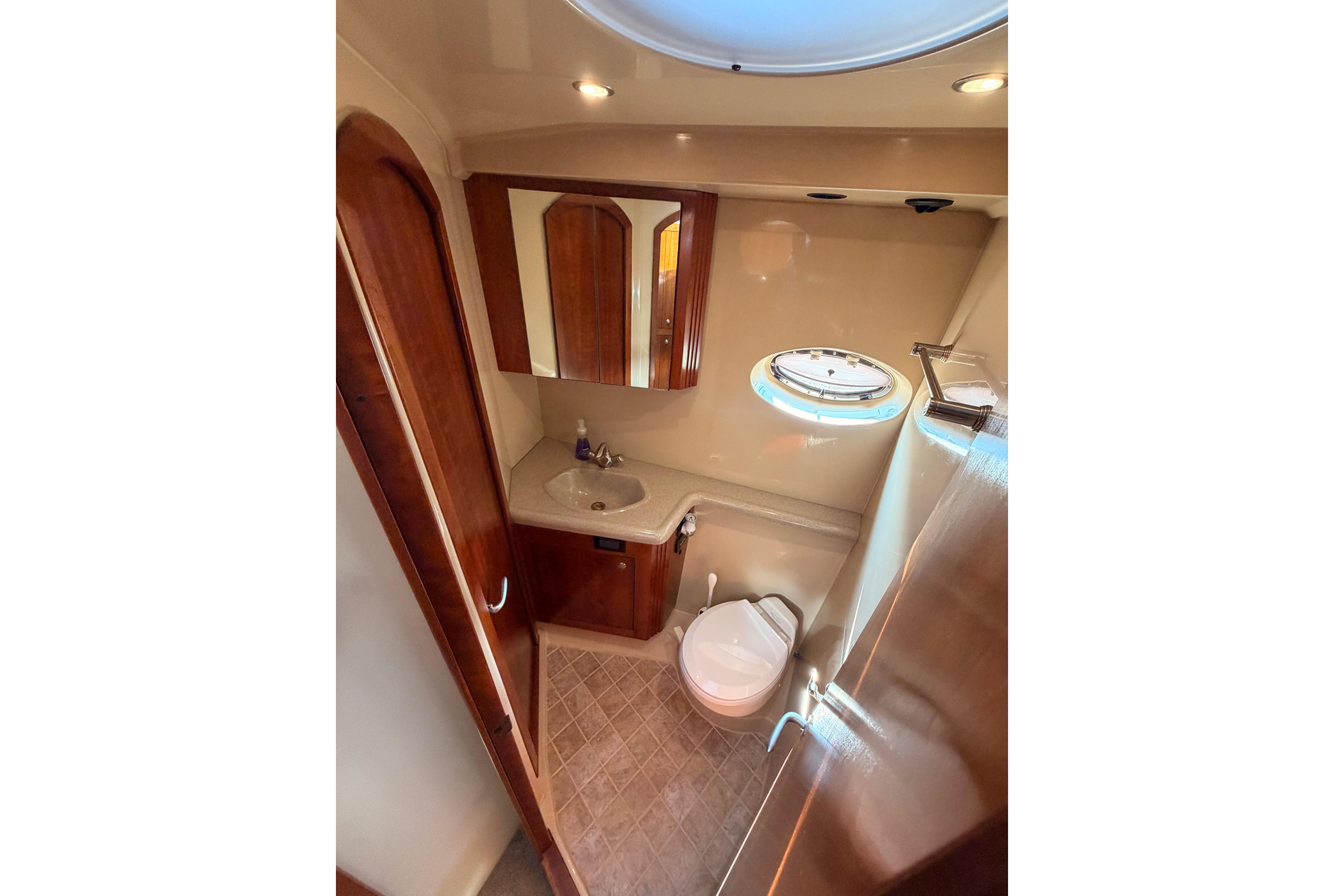Luxurious bathroom in 2005 Cruisers Yachts 405 Express Motoryacht with elegant wood finishes.