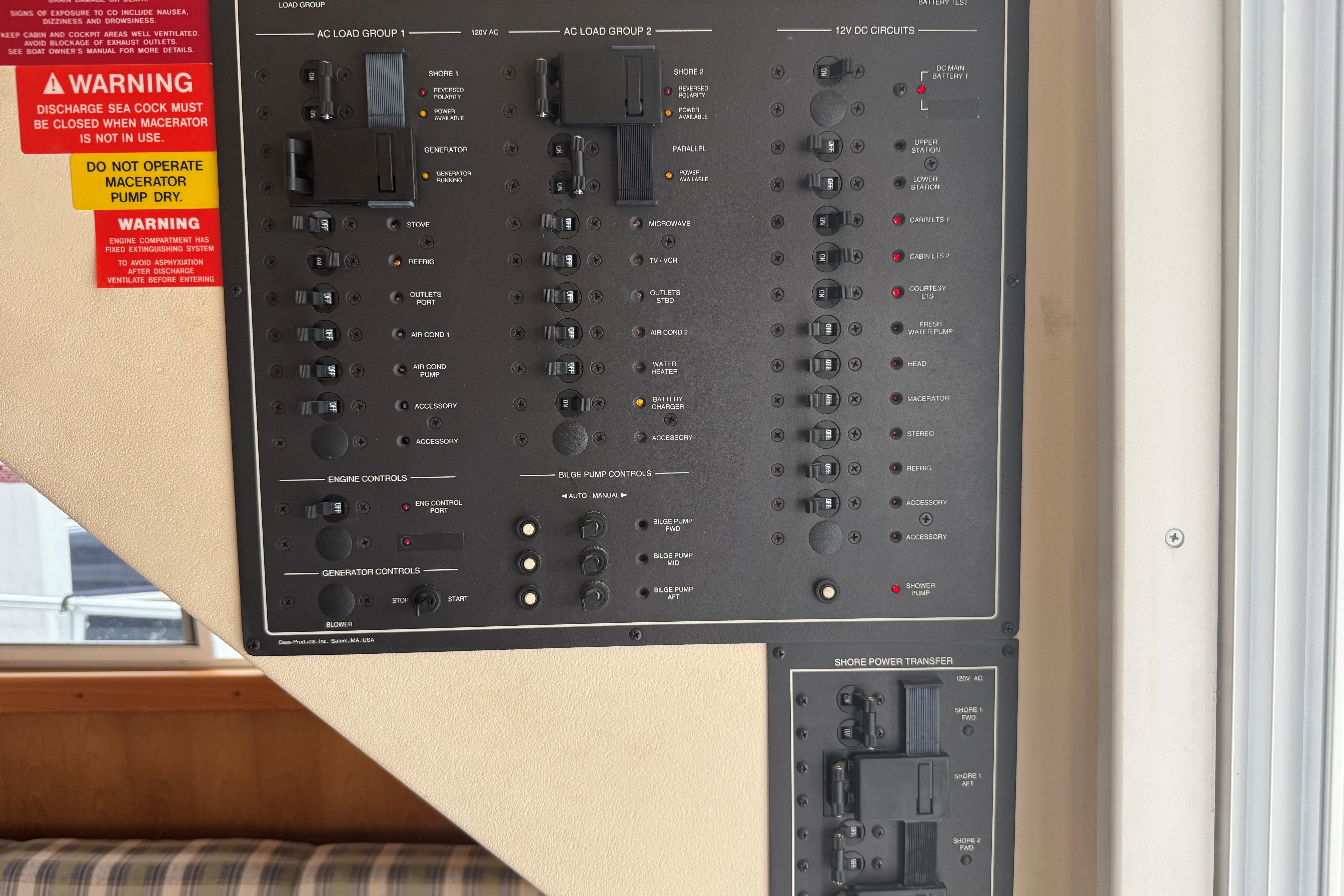 Control panel of a 1999 Mainship 350 Trawler with various switches and warning labels.
