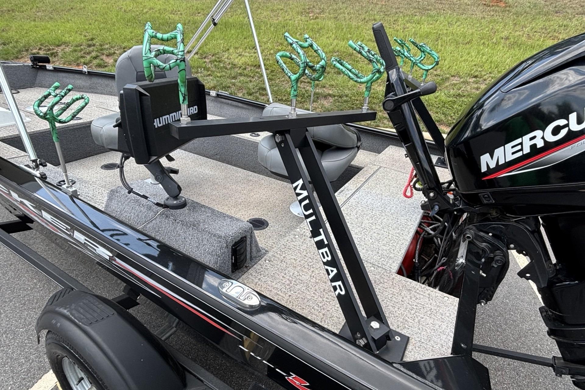2022 Tracker Super Guide V-16 T boat with fishing rod holders and Mercury engine.