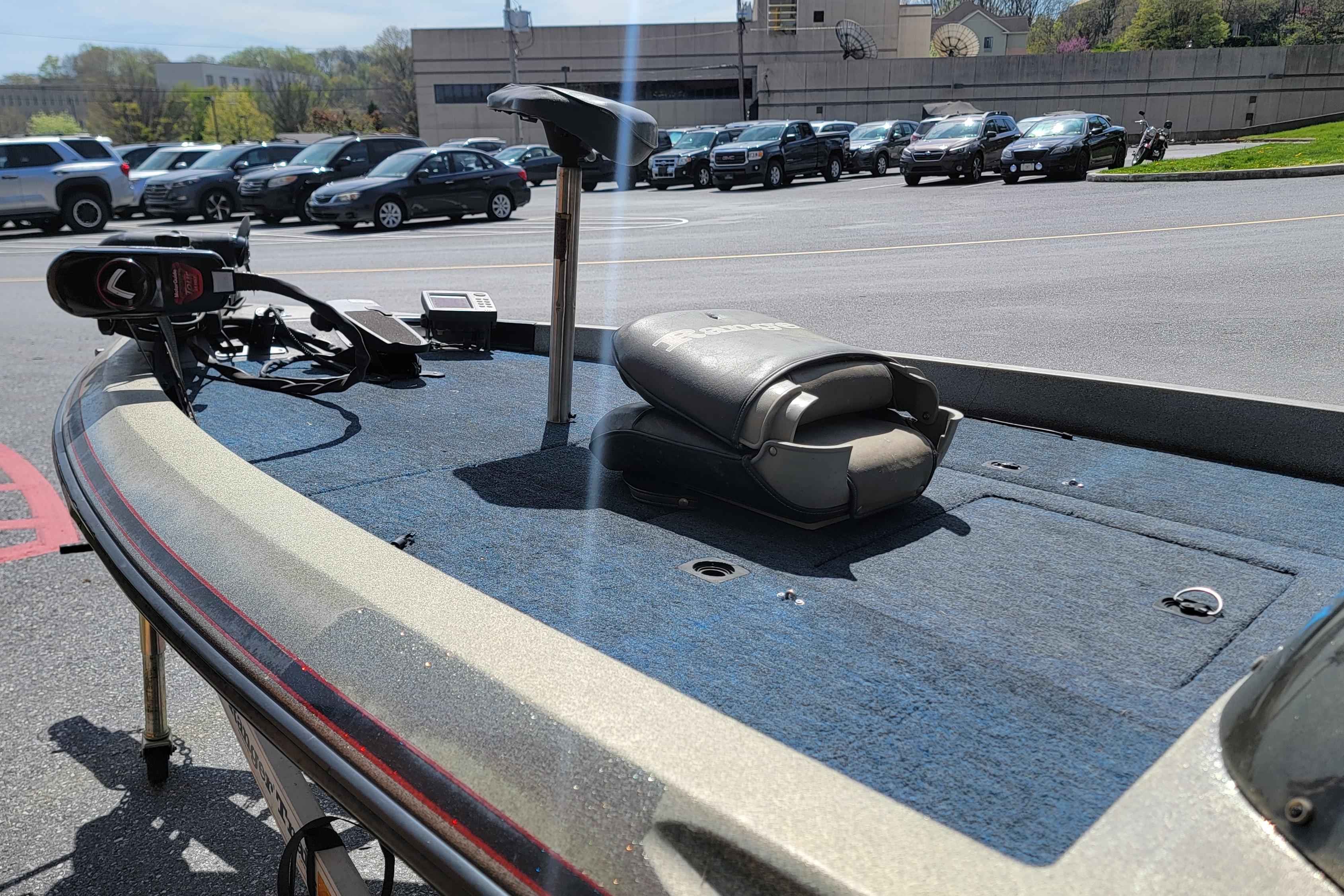 1995 Ranger boat deck with trolling motor and seat in parking lot.