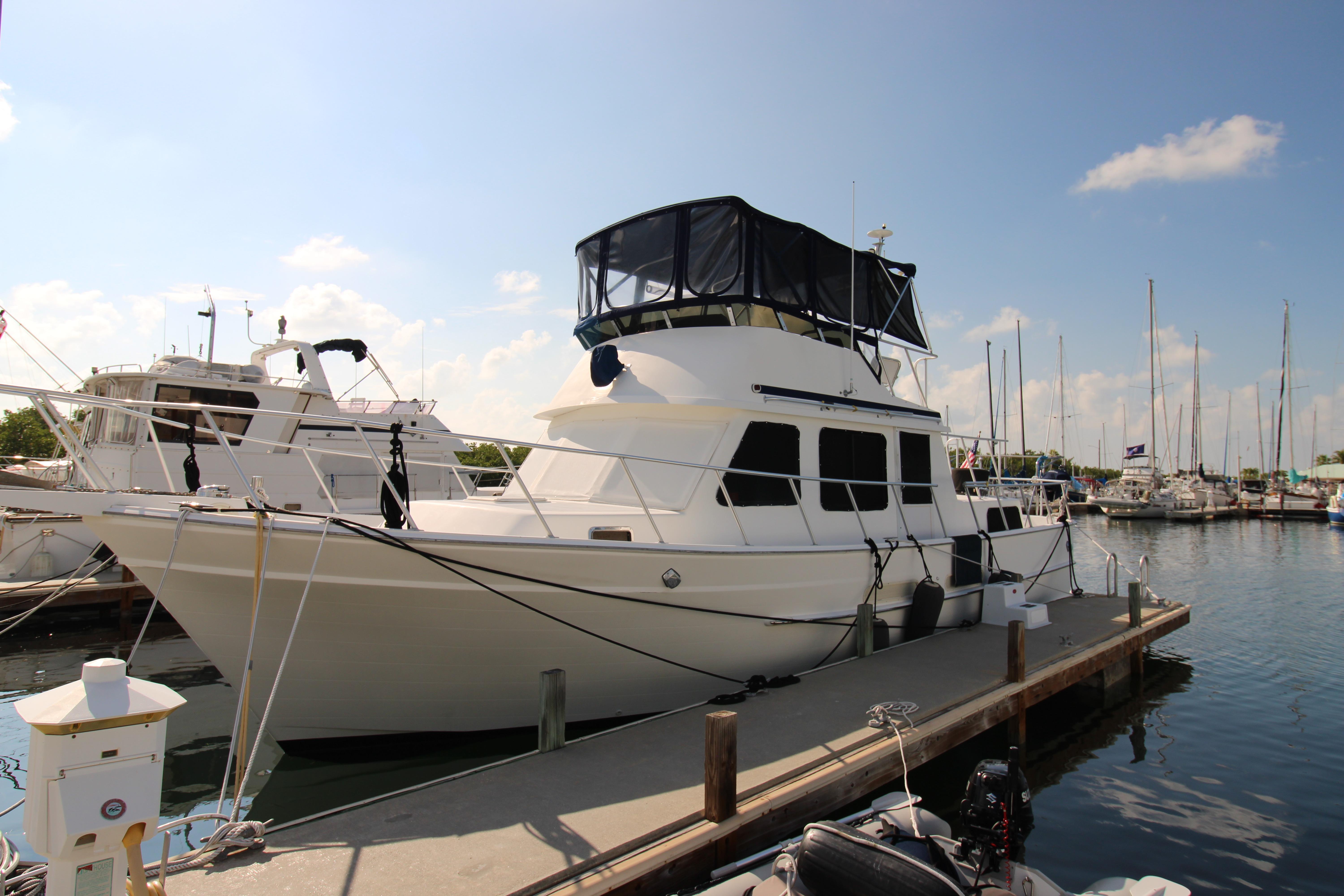 2000 Ricker 42 Classic yacht docked at marina under clear blue sky.