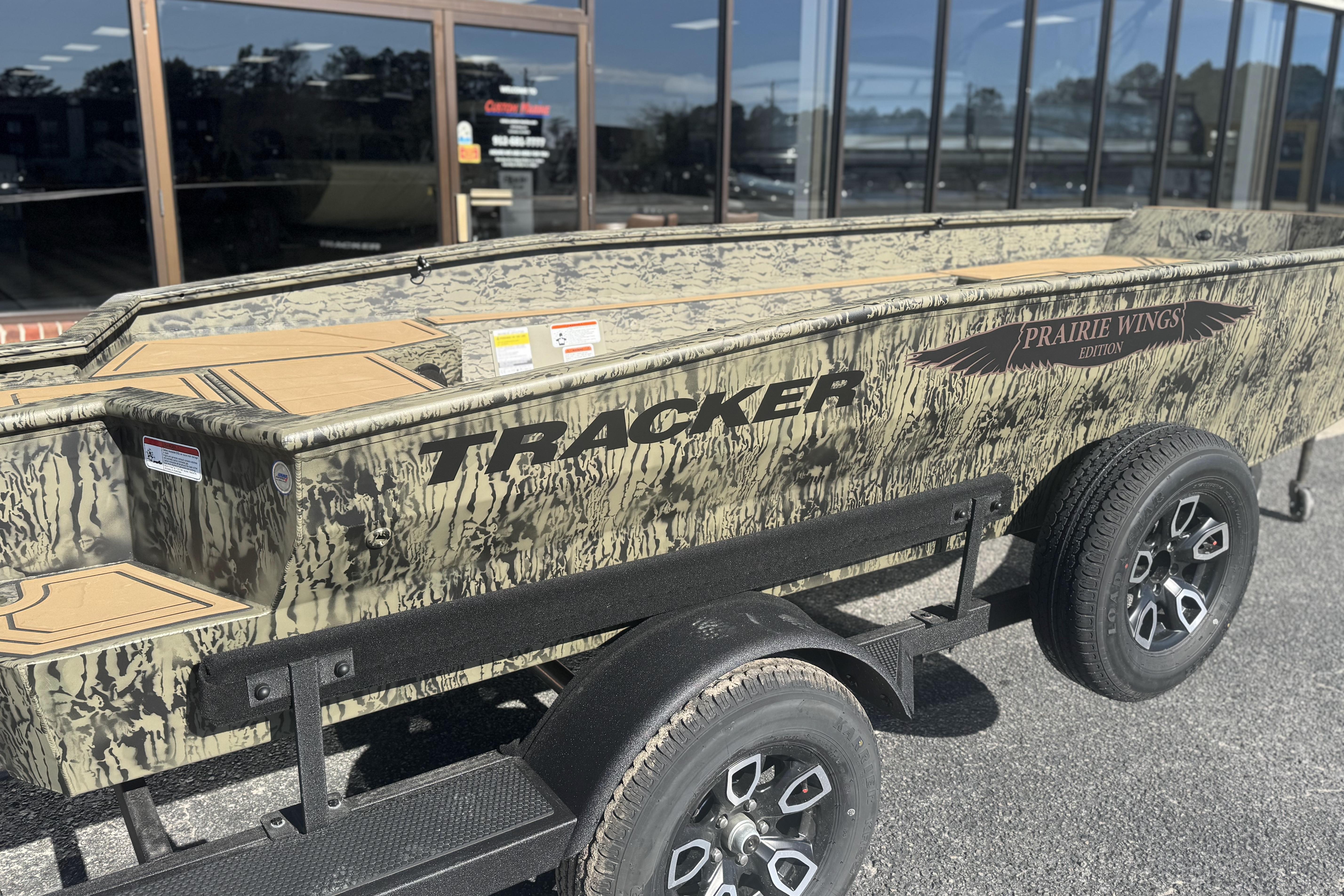 2026 Tracker Grizzly 1650 T Prairie Wings Edition boat with camouflage design on a trailer.