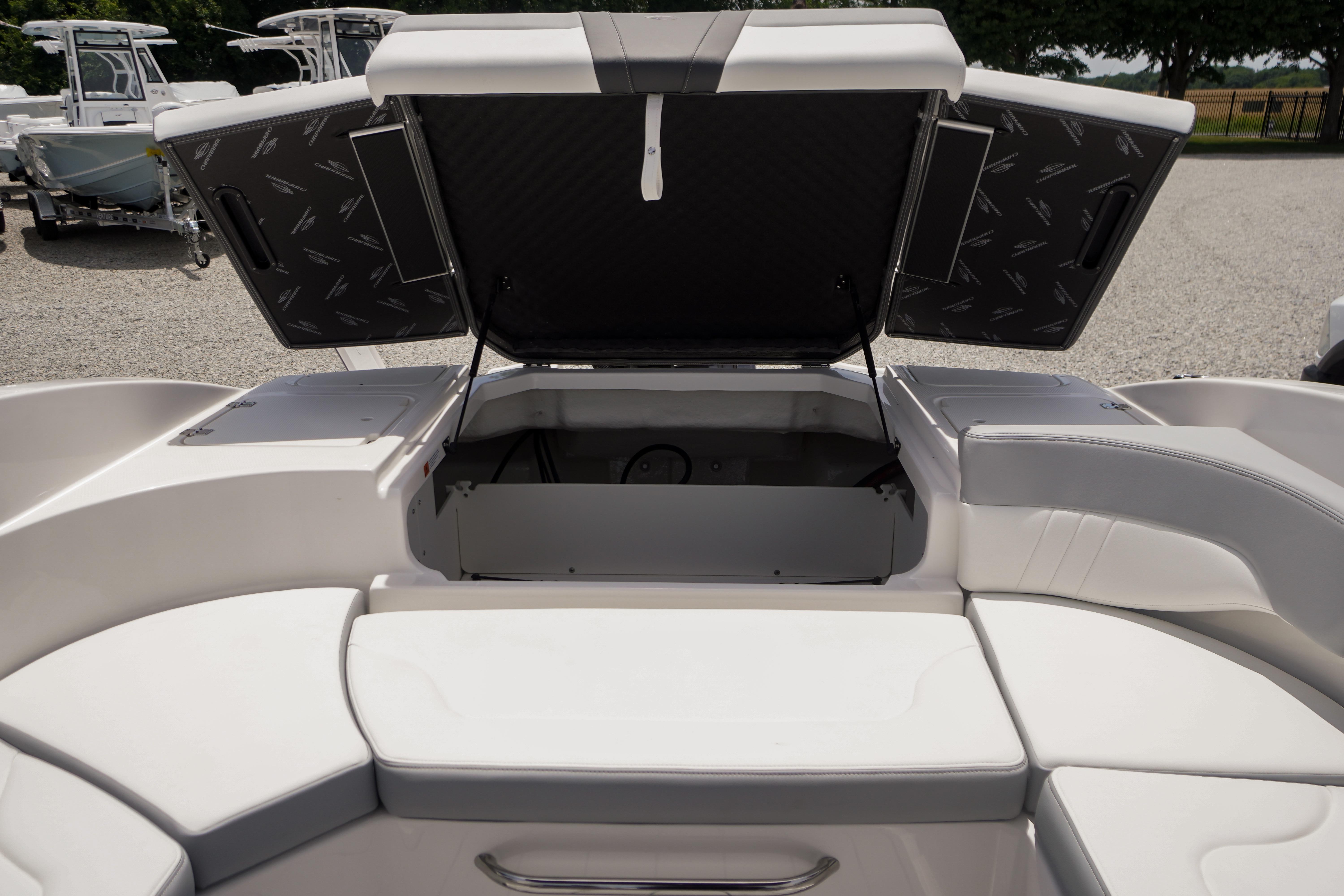2026 Chaparral 23 SSi OB boat with open storage compartment, showcasing sleek interior design.
