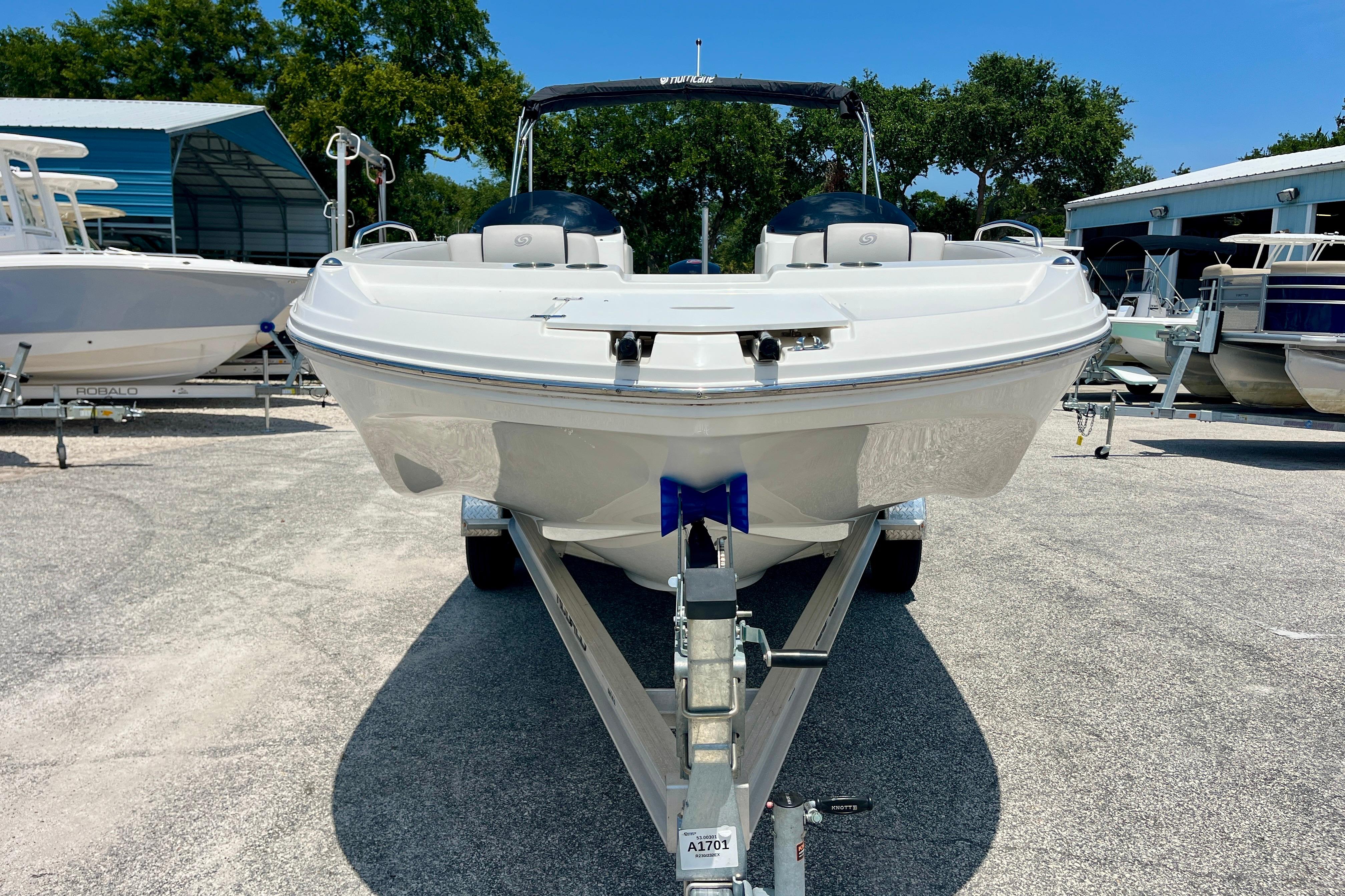 2024 Hurricane Sundeck Sport 218 OB boat on trailer, parked outdoors.
