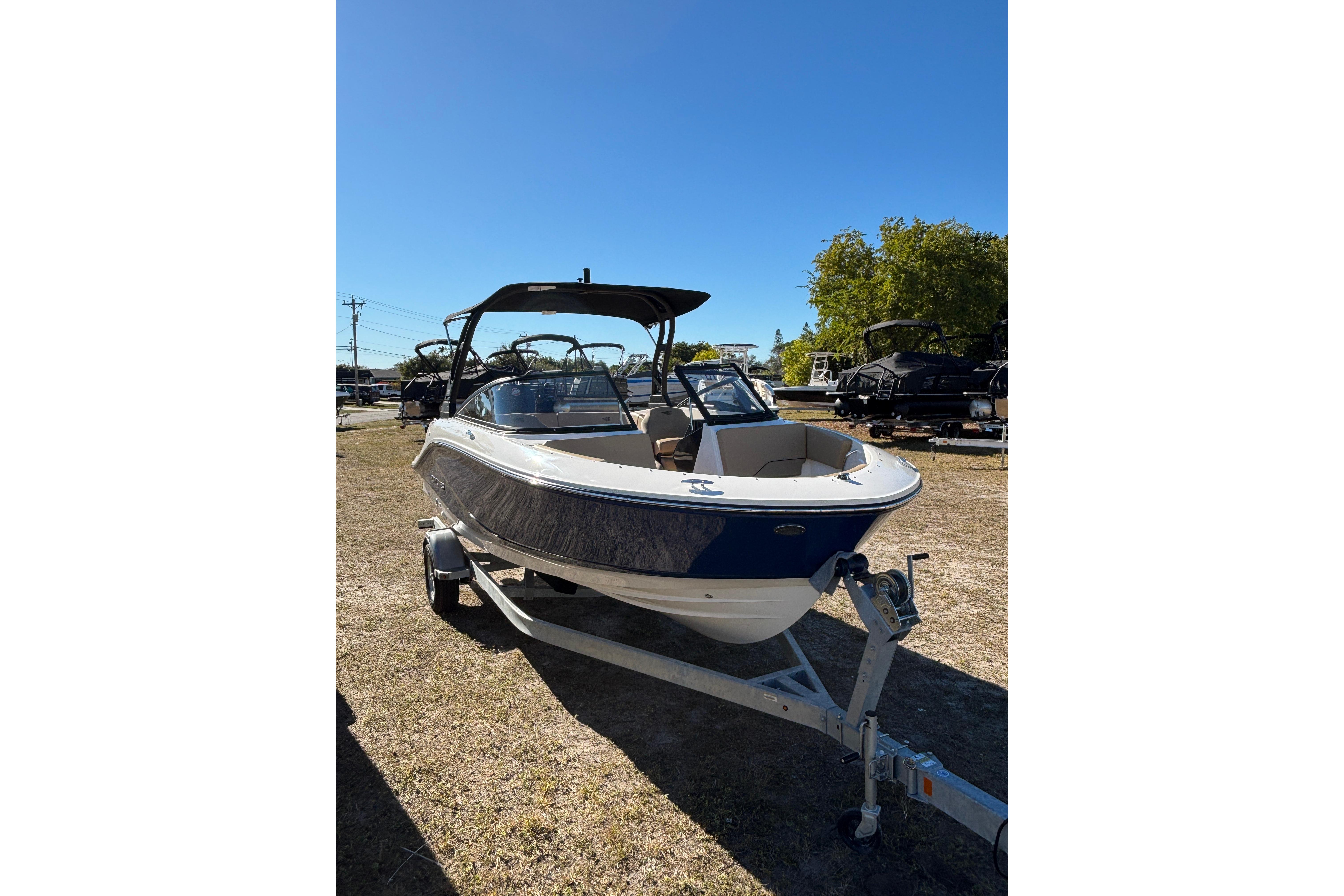 2025 Bayliner V20 boat on trailer under clear blue sky.