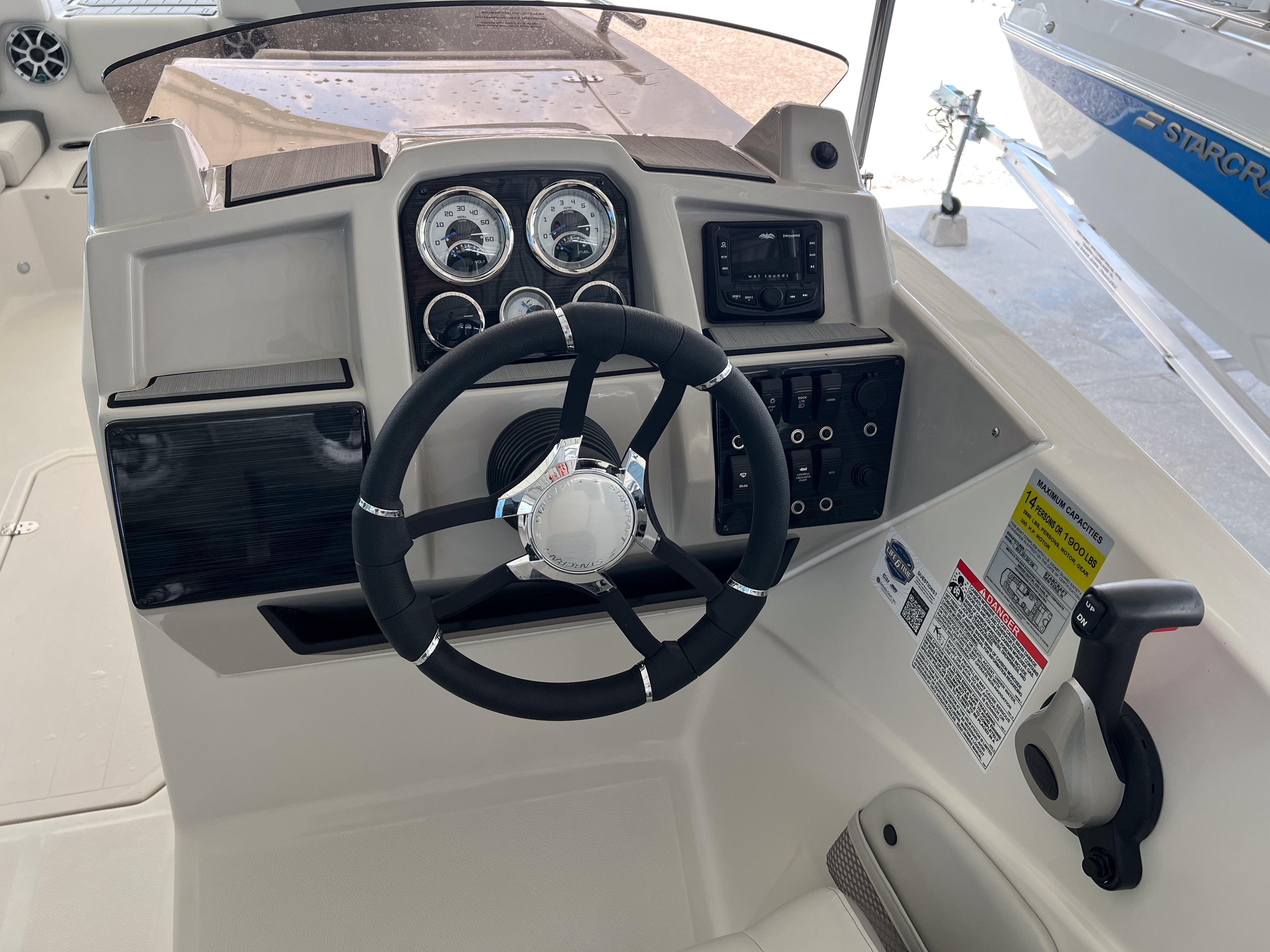Steering console of 2026 Starcraft SVX 231 OB boat with gauges and controls.