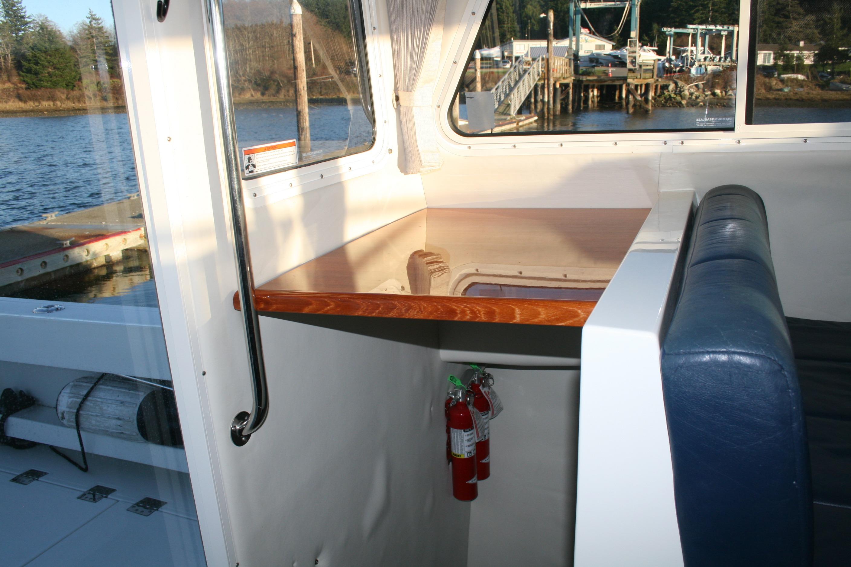 Interior of 2005 Ocean Sport 30' boat with seating and table, dock view.