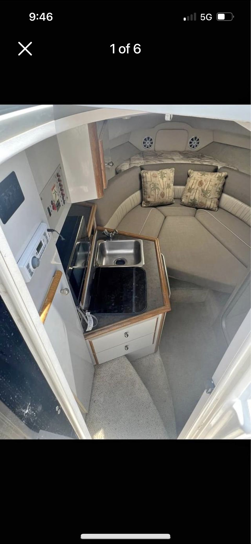 Interior of a 1995 MerCruiser Sc2400 featuring a small kitchenette and seating area.