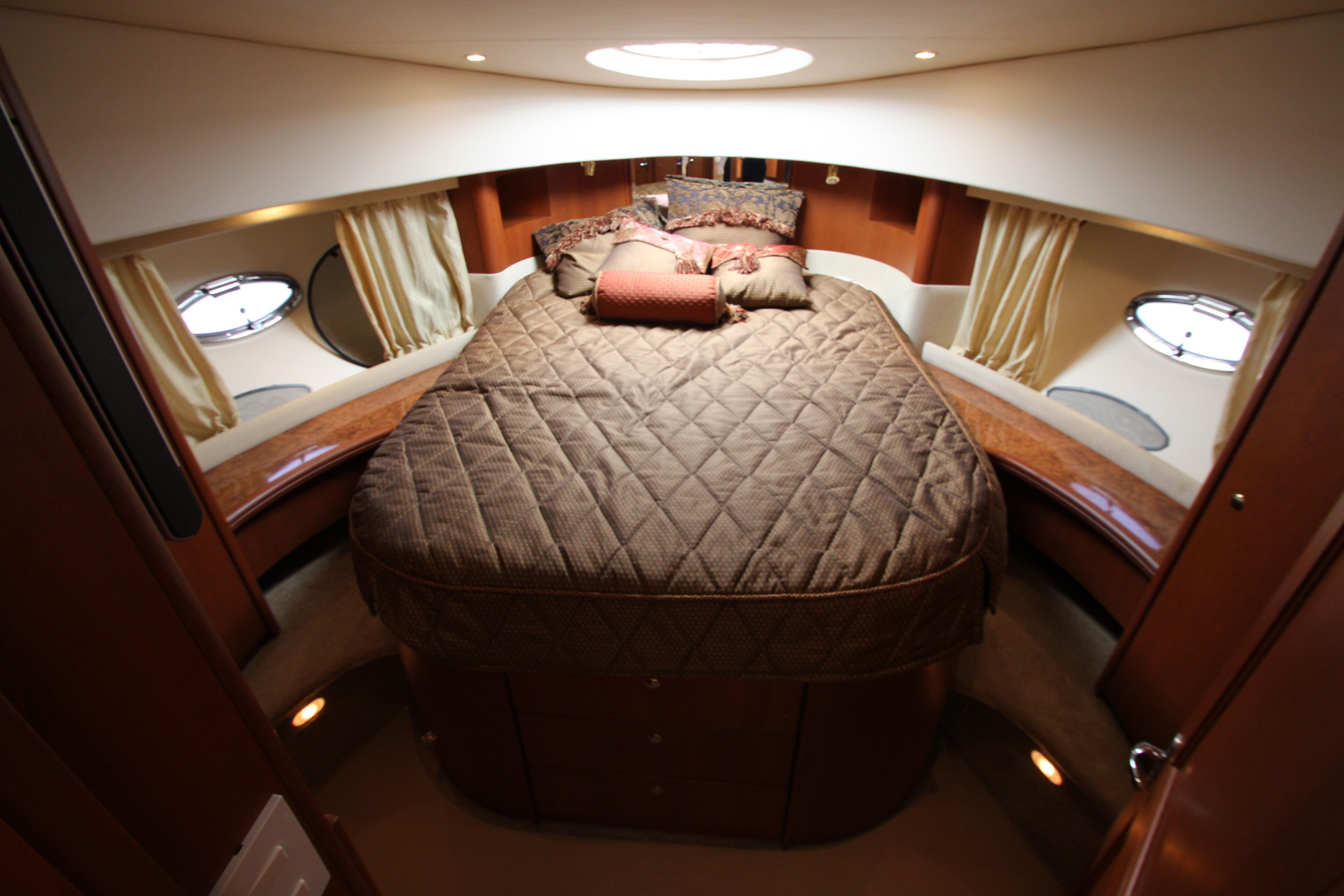 Luxurious cabin interior of a 2006 Silverton 38 Sport Bridge yacht with plush bedding.