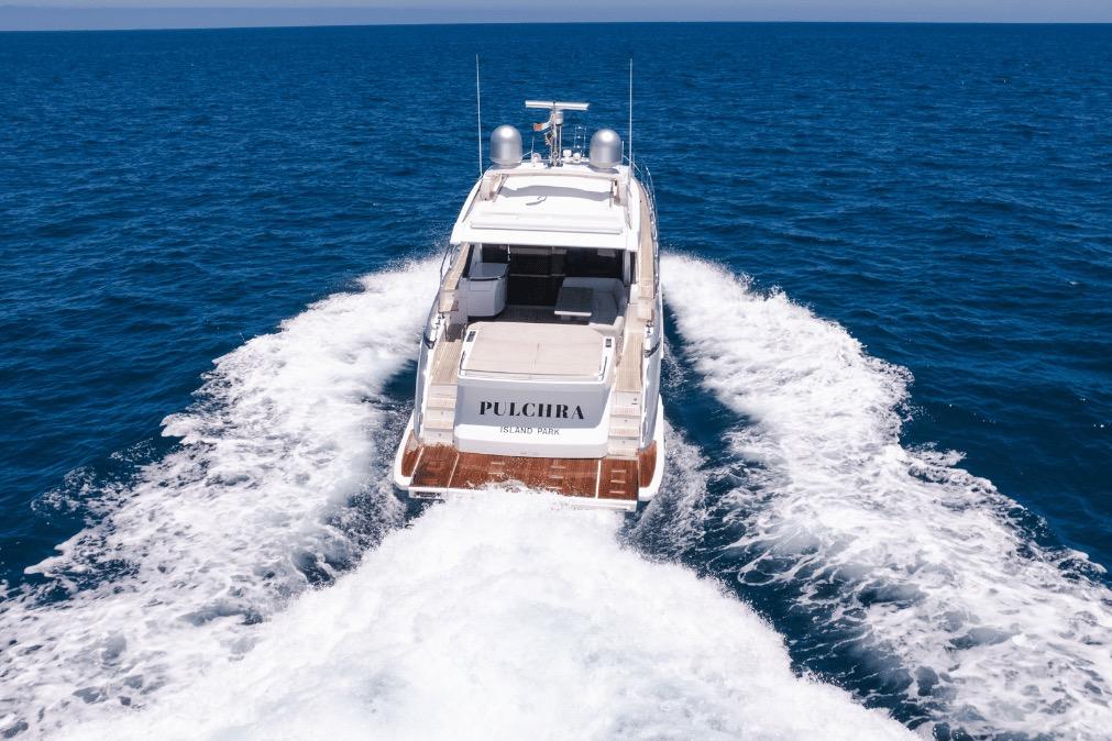 Luxury Azimut 60 yacht cruising on open sea, 2020 model, rear view.