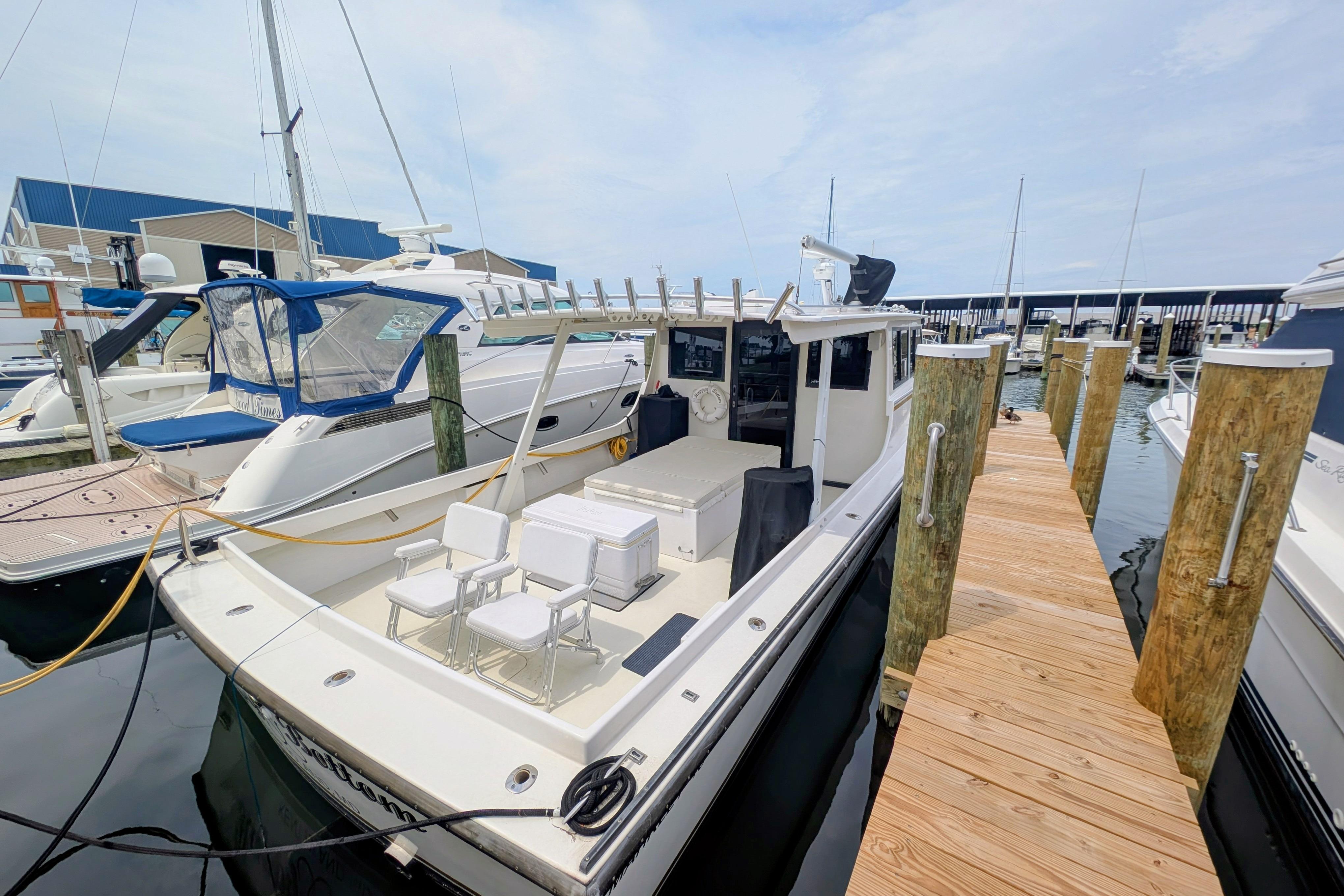 1998 Markley 46 boat docked at marina with wooden pier and neighboring vessels.