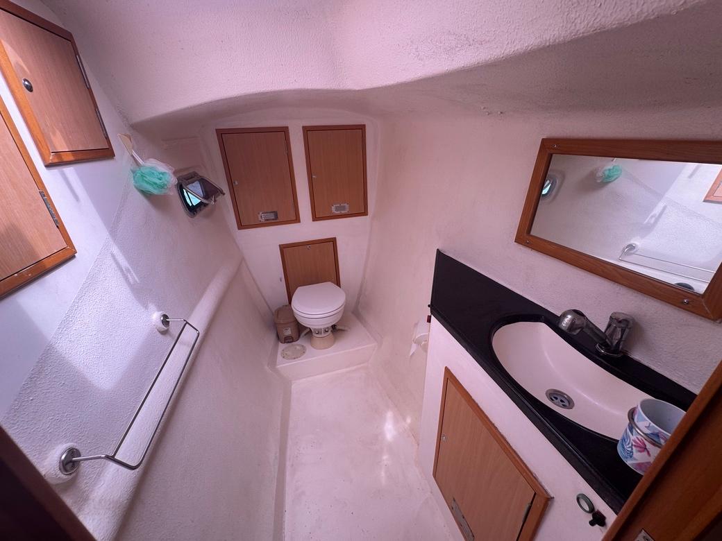 Compact bathroom in 2010 Admiral 38 Executive yacht with sink, toilet, and storage cabinets.