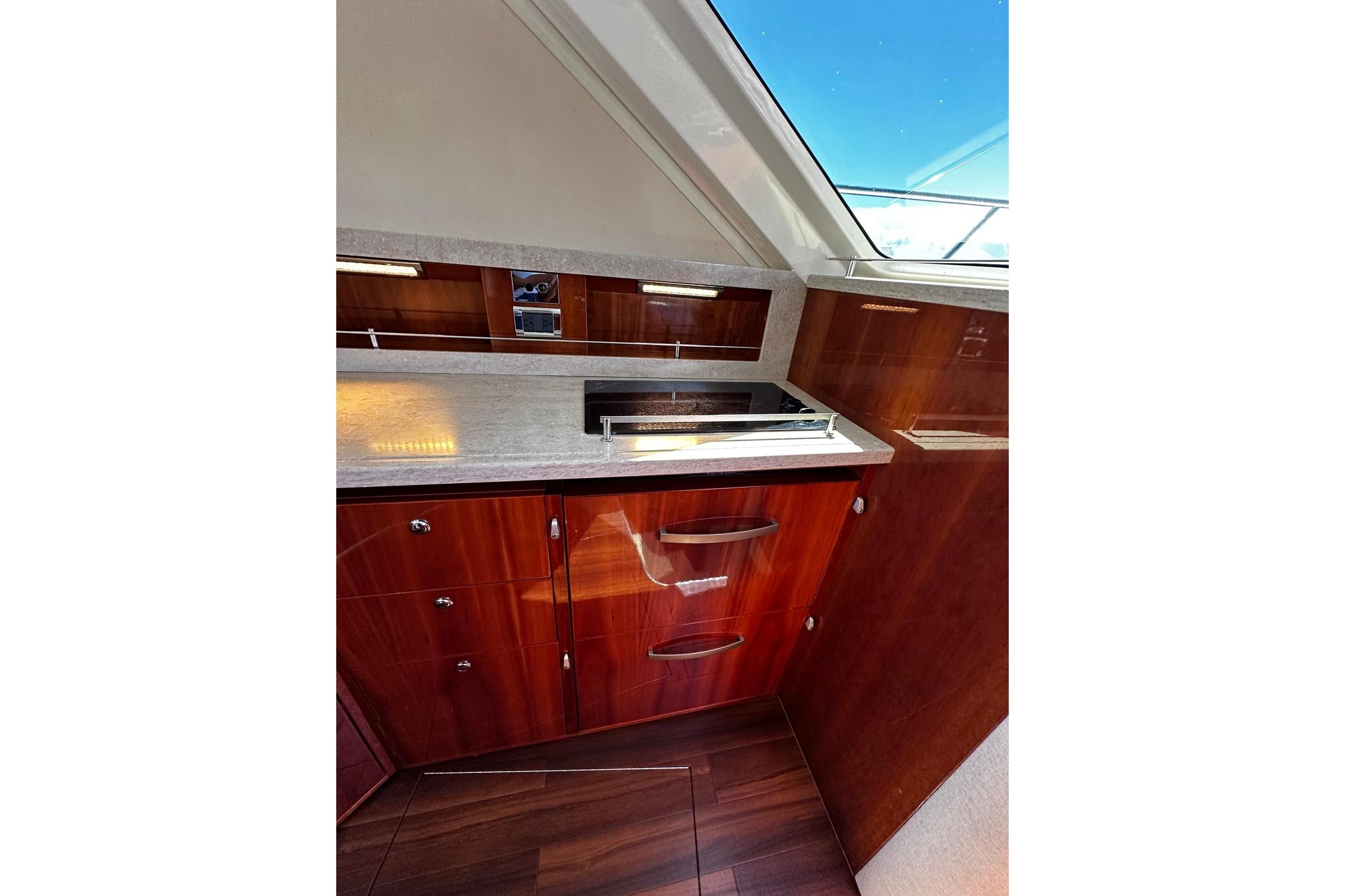 Luxurious interior of 2012 Riviera 43 Flybridge yacht with sleek wood cabinetry and modern fixtures.