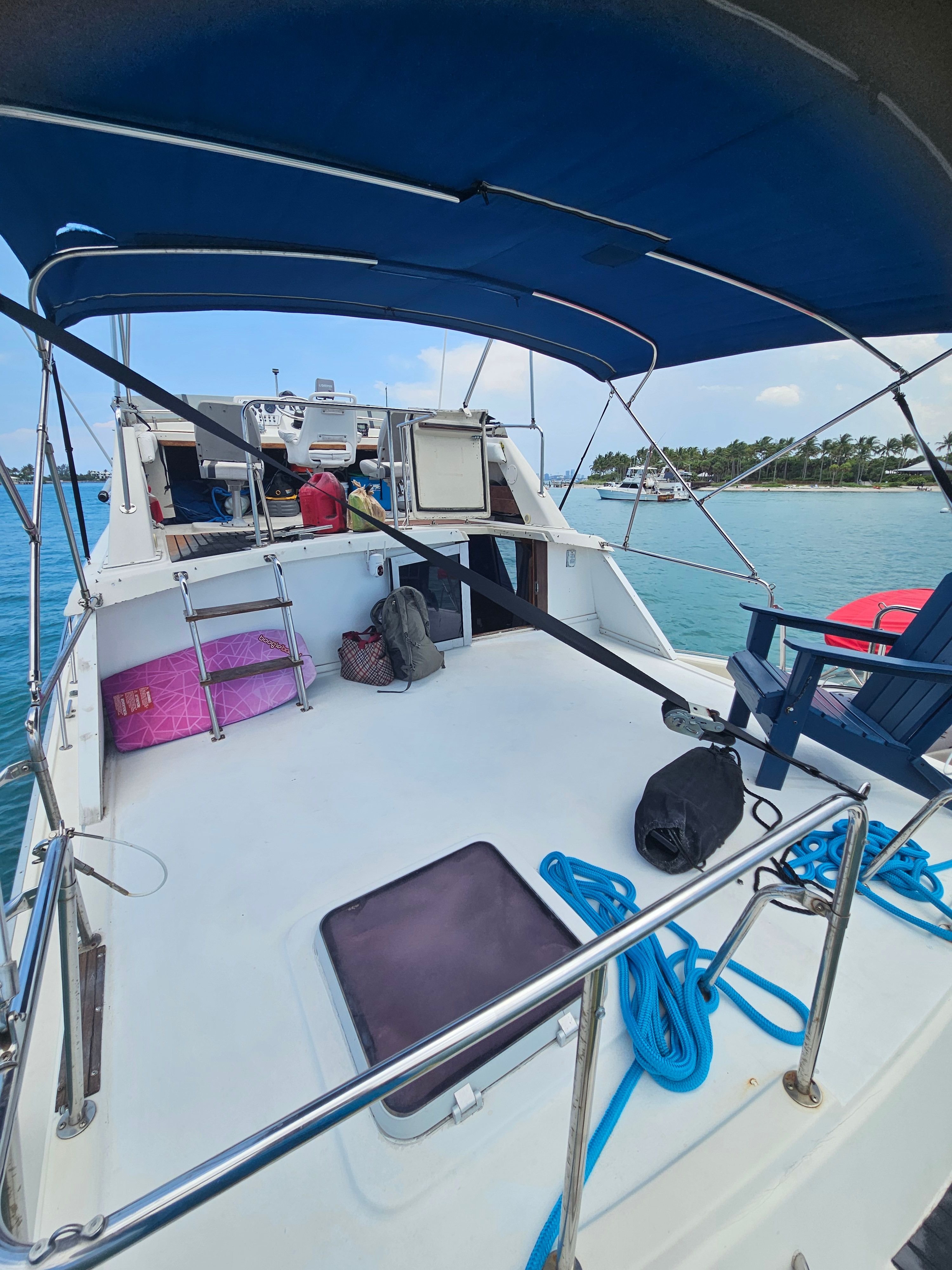 The deck of a 1984 Silverton 40 with blue canopy and ropes.