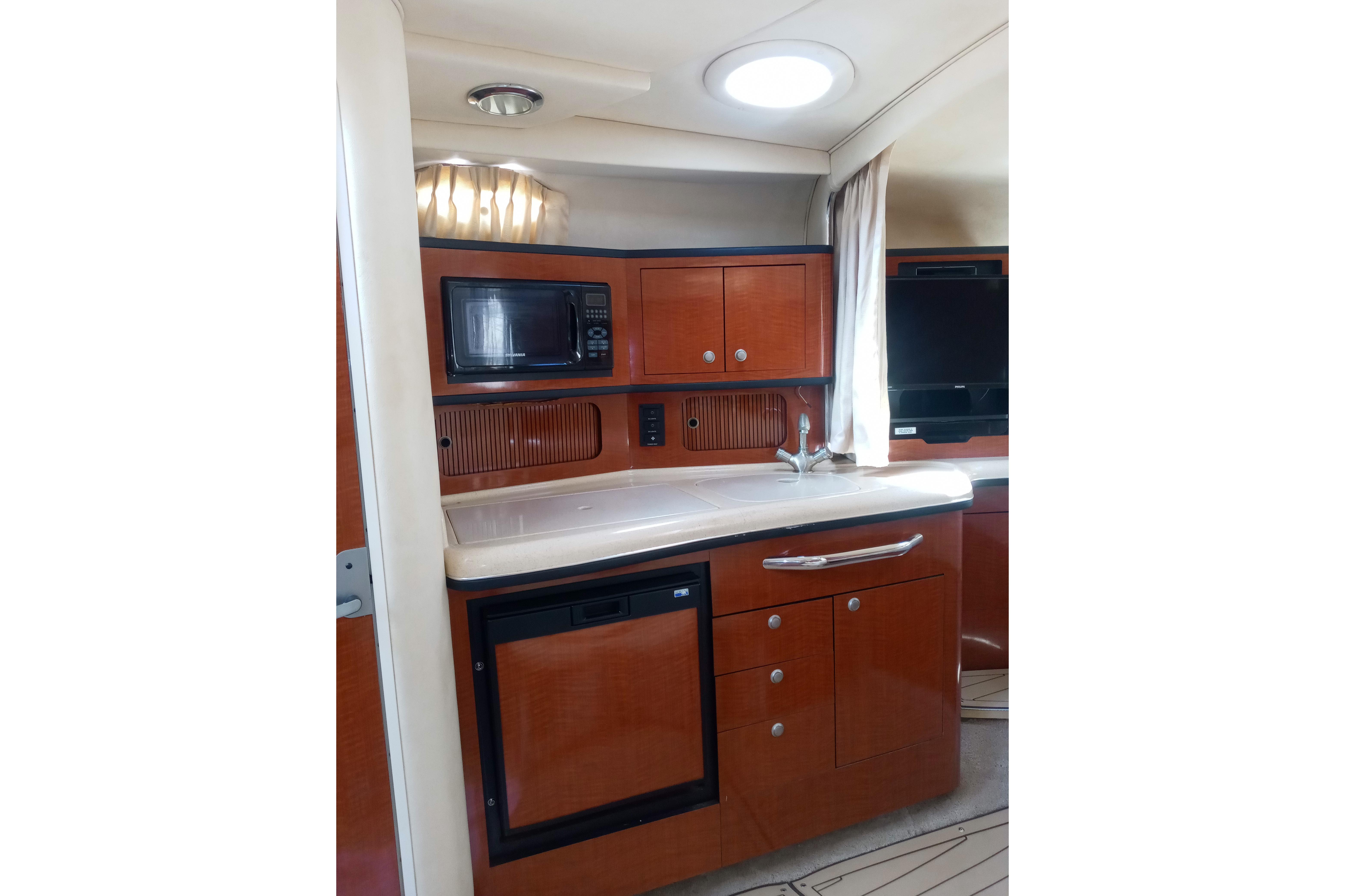 Interior of 2005 Sea Ray 300 Sundancer yacht with kitchenette and modern amenities.