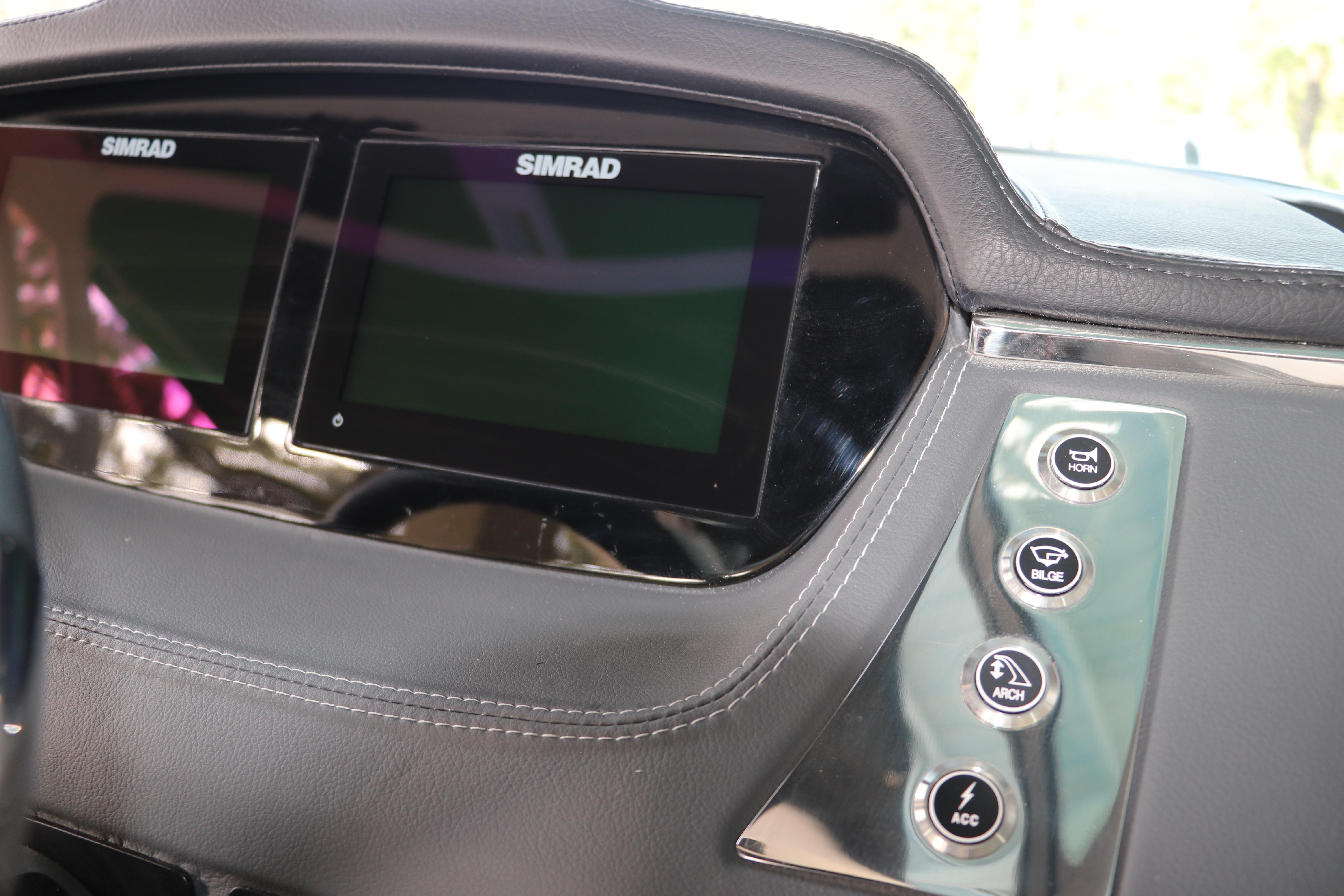 Dashboard of 2026 Chaparral 250 OSX with Simrad displays and control buttons.