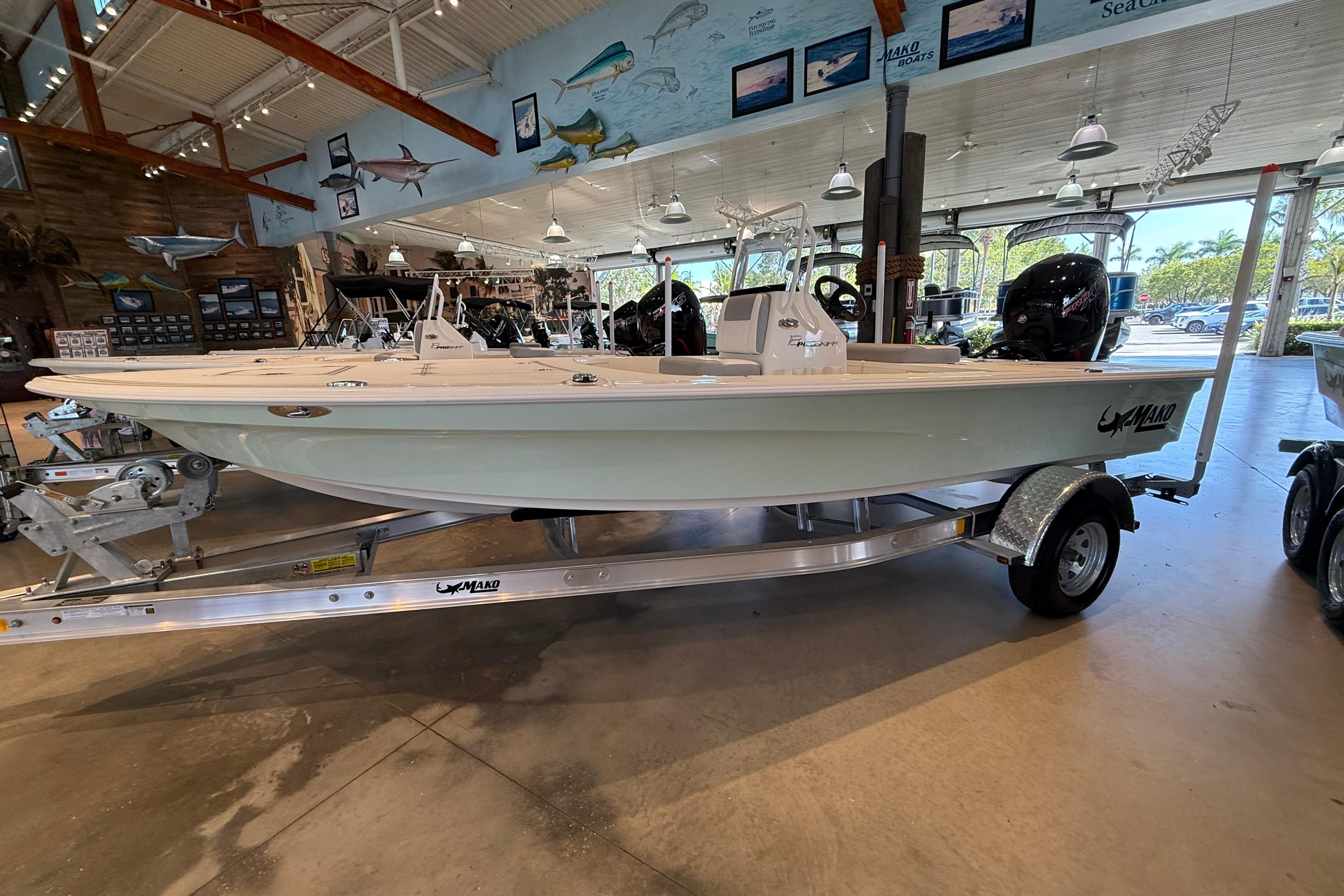 2026 Mako 18 Pro Skiff boat displayed indoors on a trailer.