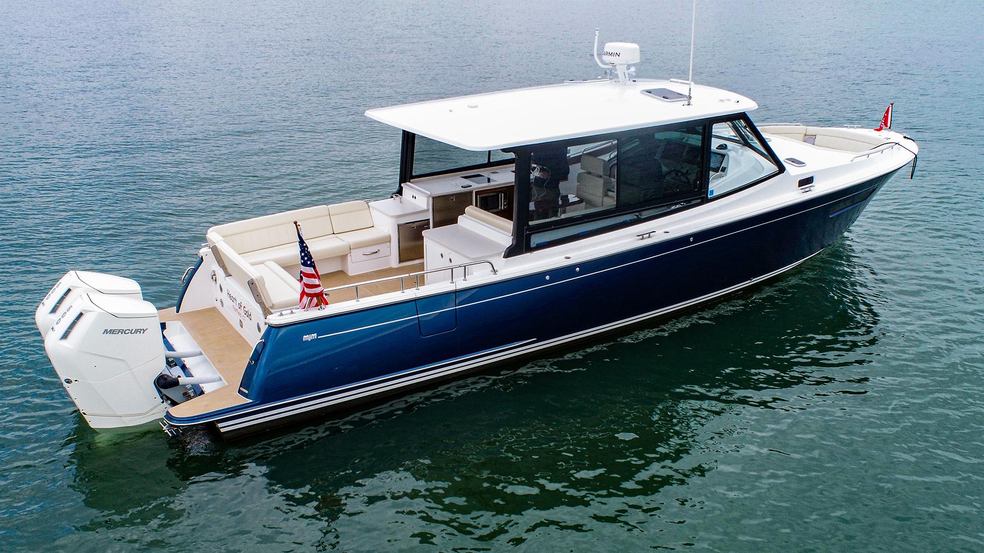 2024 MJM 4 boat on water, sleek design, blue hull, outboard motor.