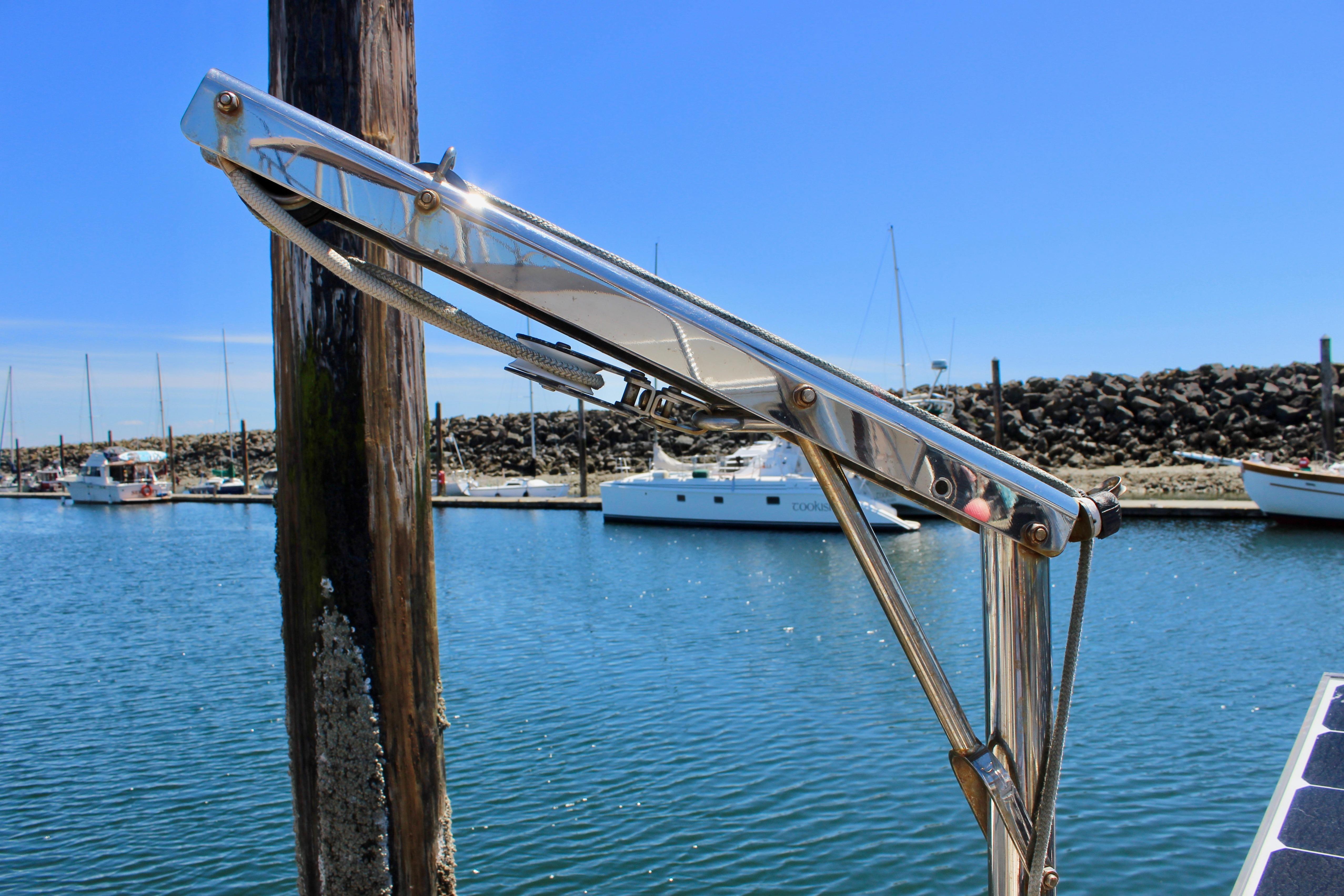 Stainless steel davit on a 1981 Kelly Peterson 46 sailboat in a marina.