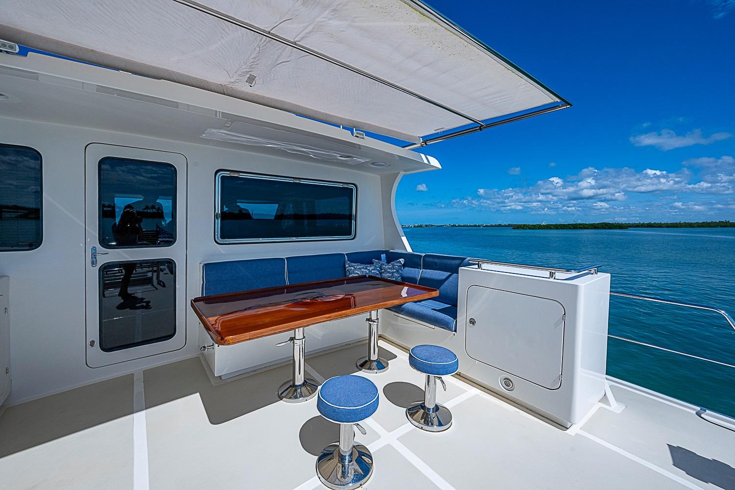 Outdoor seating area on 2014 Marlow 80 Explorer yacht with ocean view.