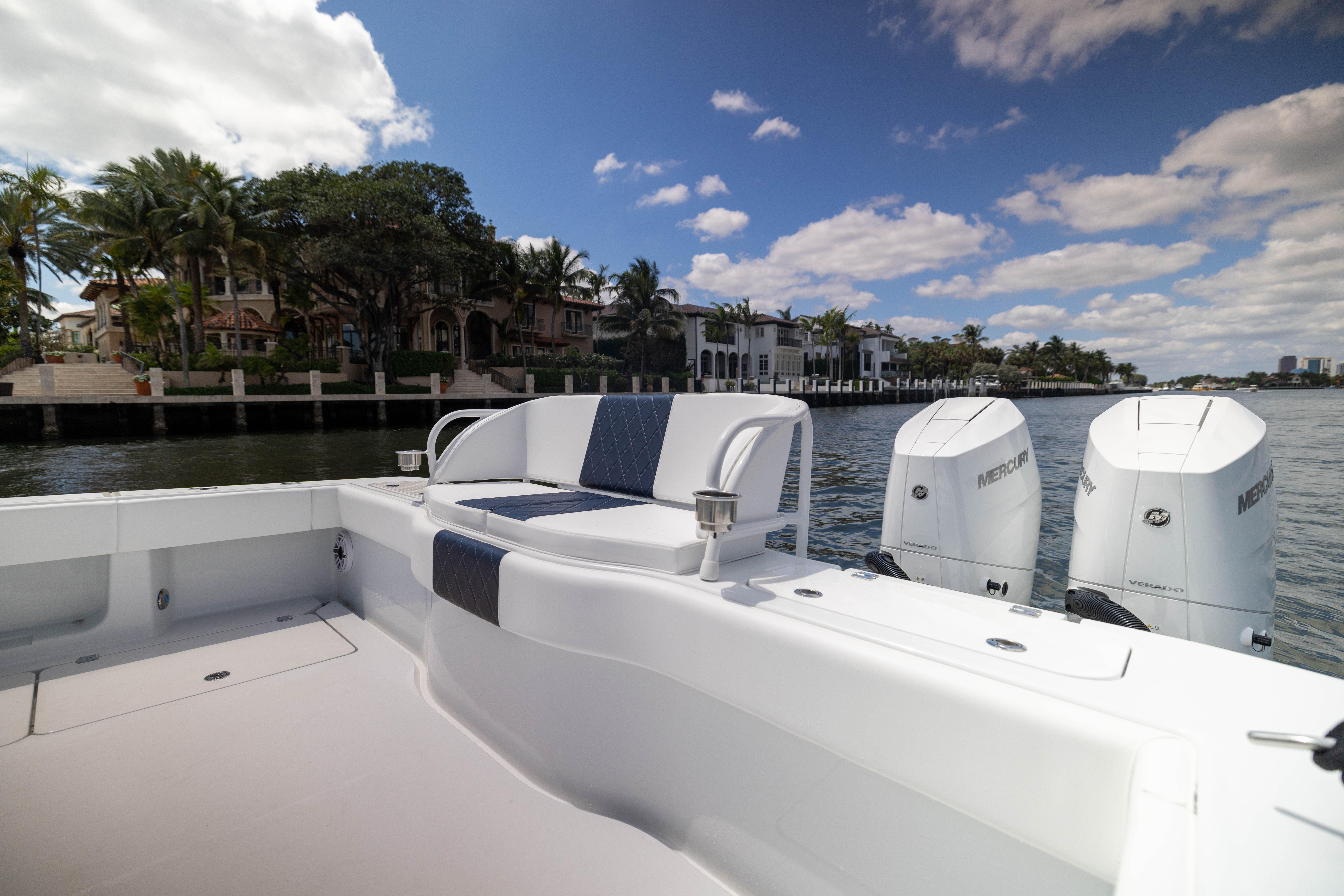 2026 Freeman 47 LX boat with Mercury engines, docked near luxury waterfront homes.