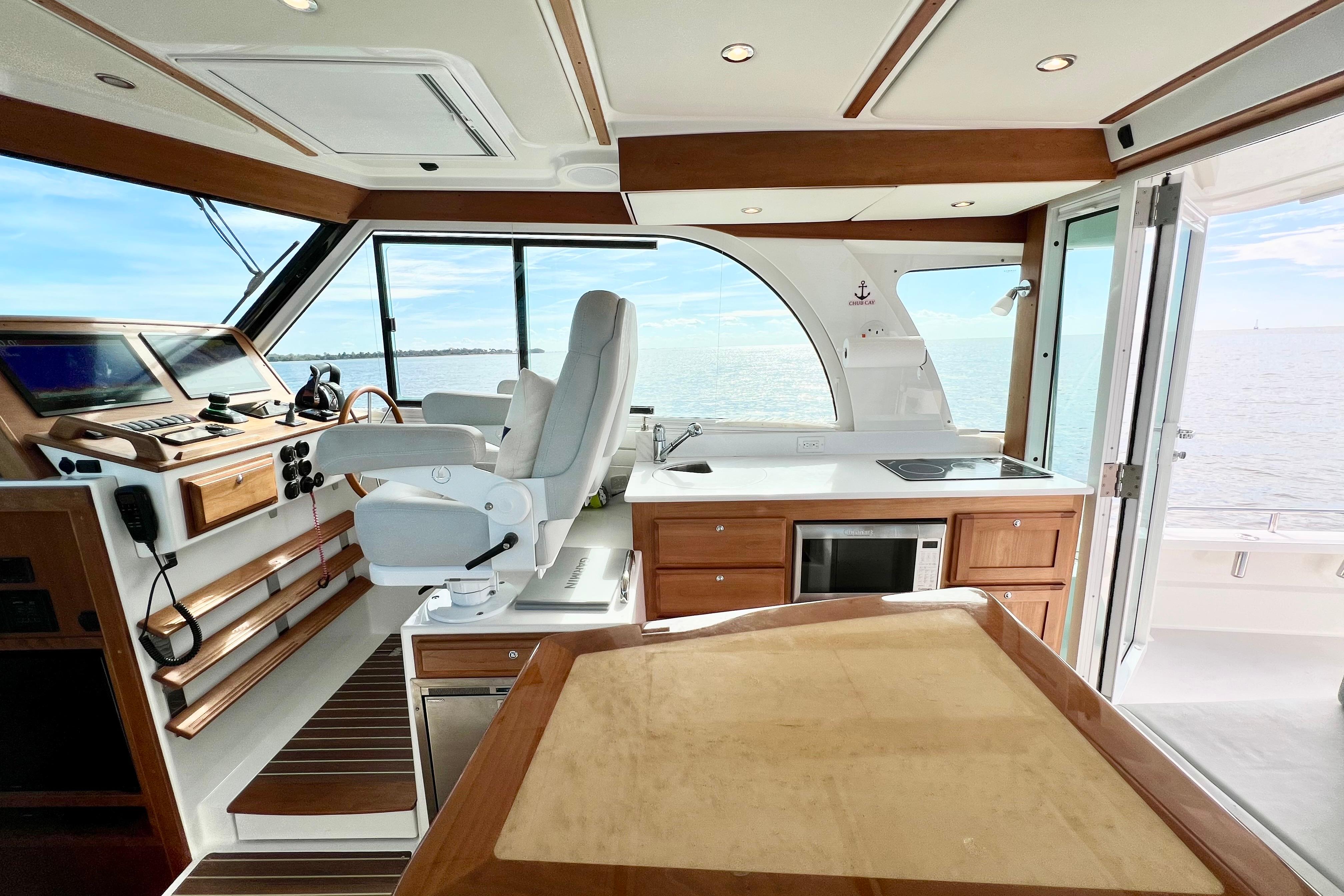 Interior of 2021 Back Cove 390 yacht with helm, kitchen, and ocean view.