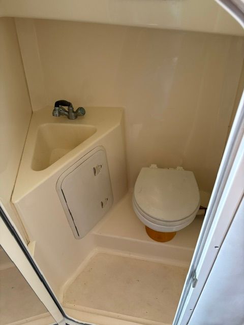 Small bathroom with toilet and sink on a boat.
