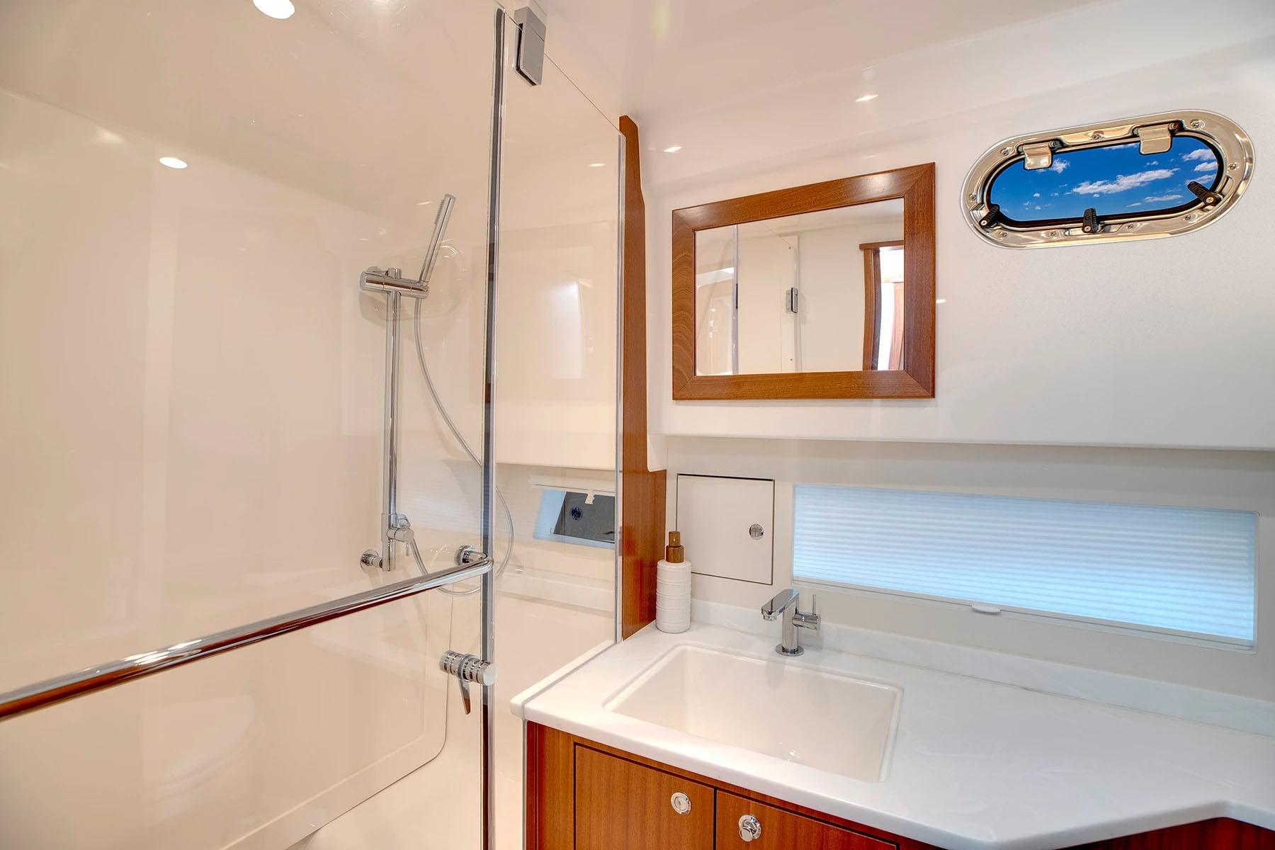 Manufacturer Provided Image: Luxurious bathroom in 2025 Pursuit OS 445 Offshore yacht with modern fixtures and porthole window.