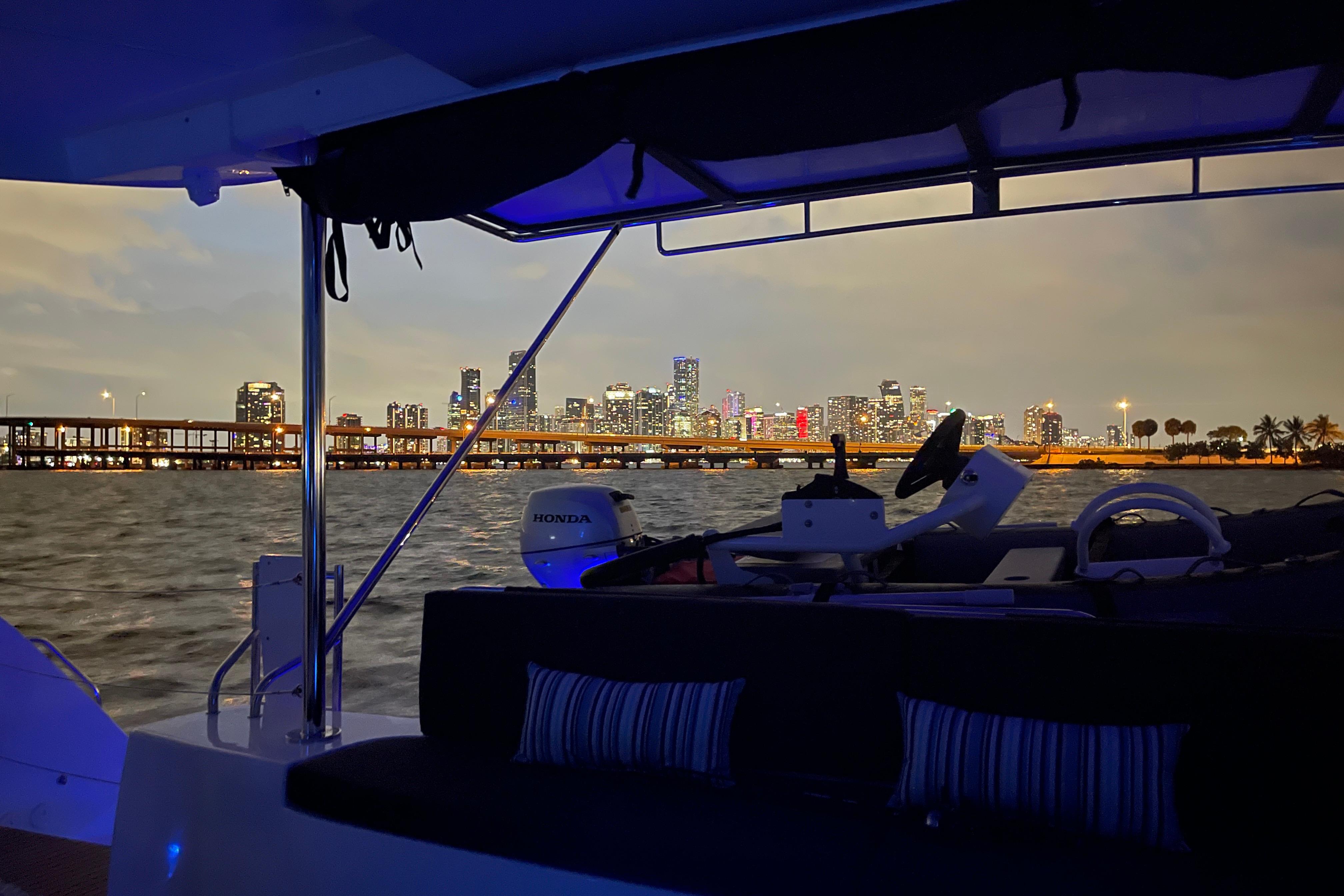 2024 Lagoon 46 yacht with city skyline view at dusk.