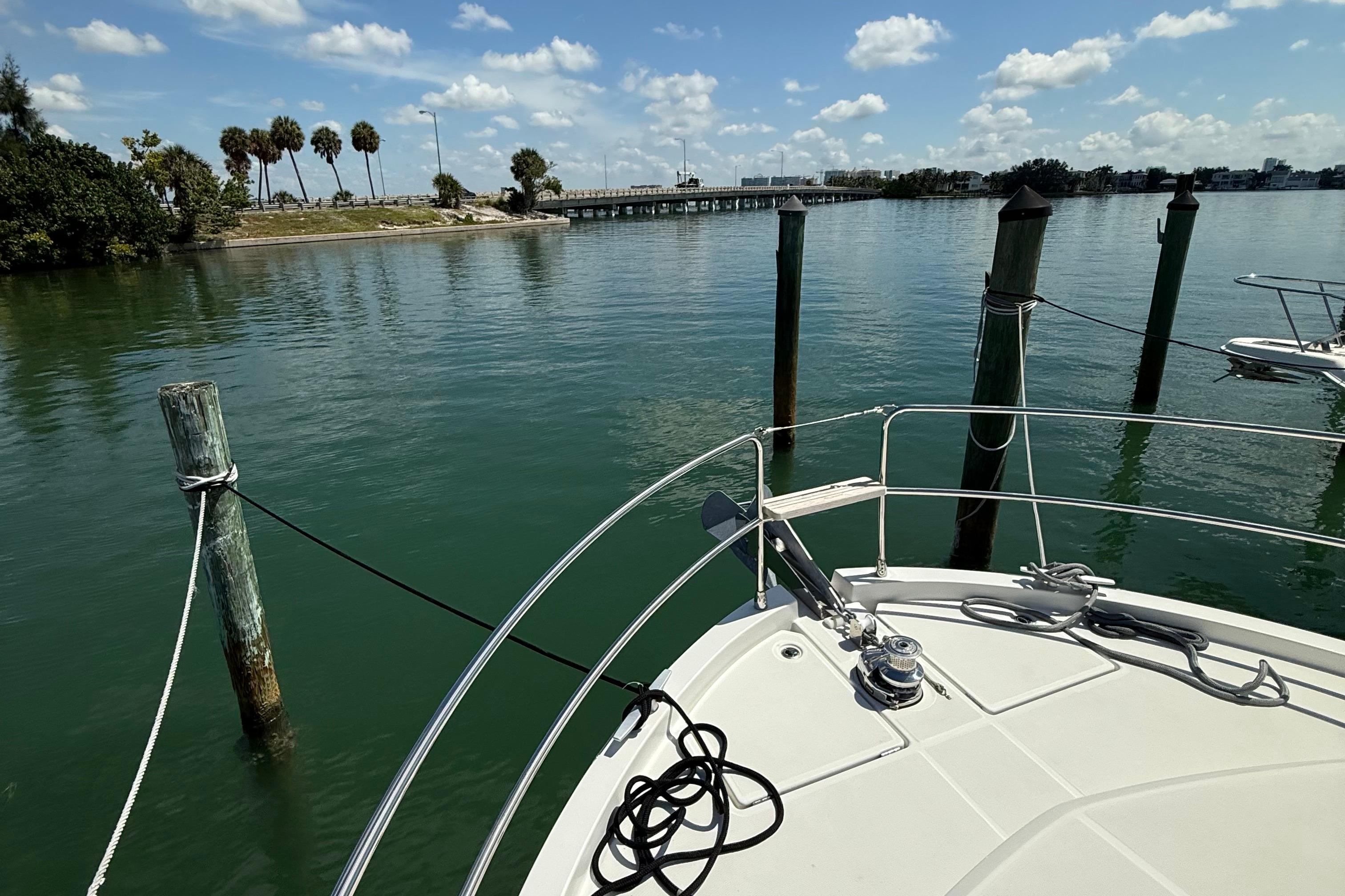 Bow of 2021 Beneteau Swift Trawler 35 docked in serene waters under blue sky.