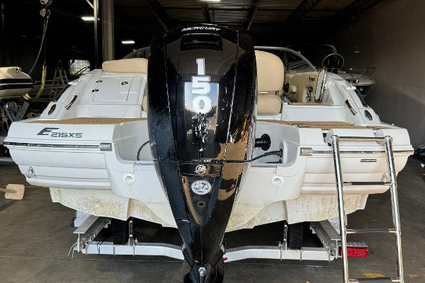 2023 Crownline 215 XS boat with Mercury 150 engine in a garage.