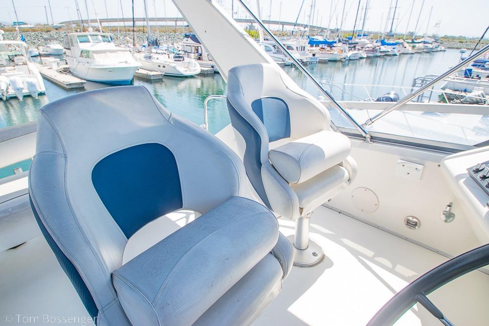 1991 Sea Ray 370 Sedan Bridge helm with marina view, featuring comfortable captain chairs.