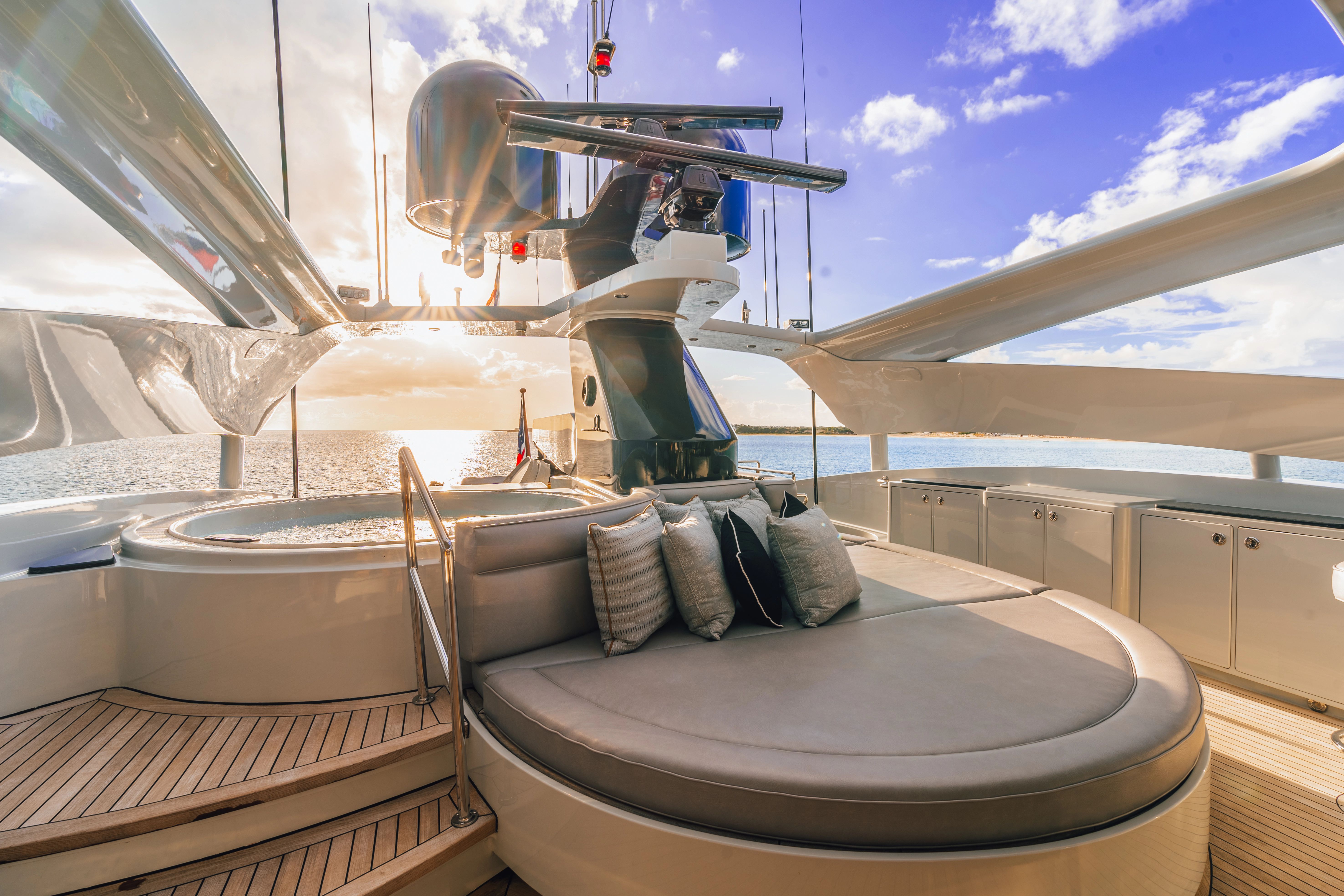 Luxurious deck of a 2005 Palmer Johnson Raised Pilothouse yacht with sun loungers and sea view.