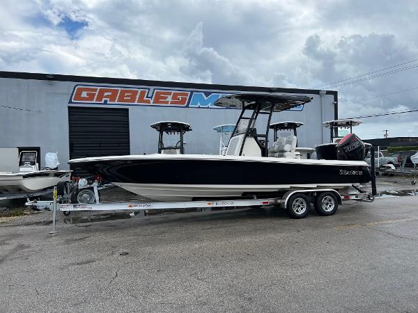 2024 ShearWater 260 Carolina Flare boat on trailer, parked outside dealership.