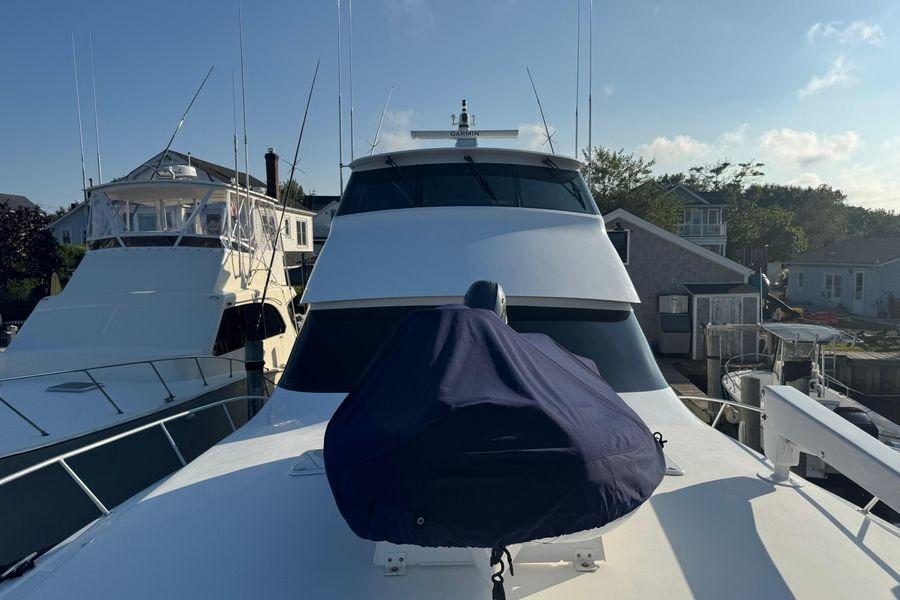 2002 Viking 61 Enclosed Bridge yacht docked at marina under clear sky.
