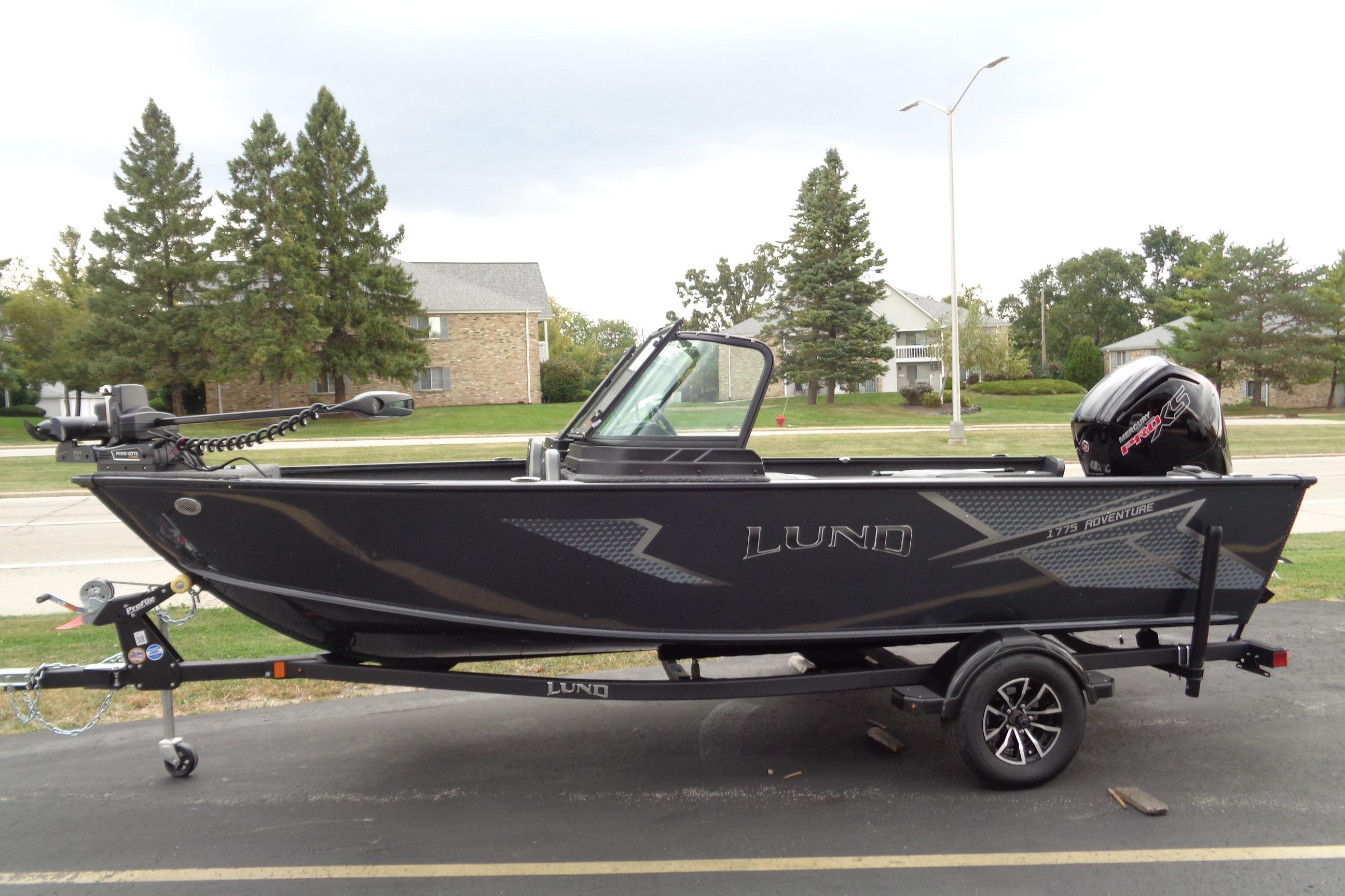2026 Lund 1775 Adventure Sport boat on trailer, parked outdoors.