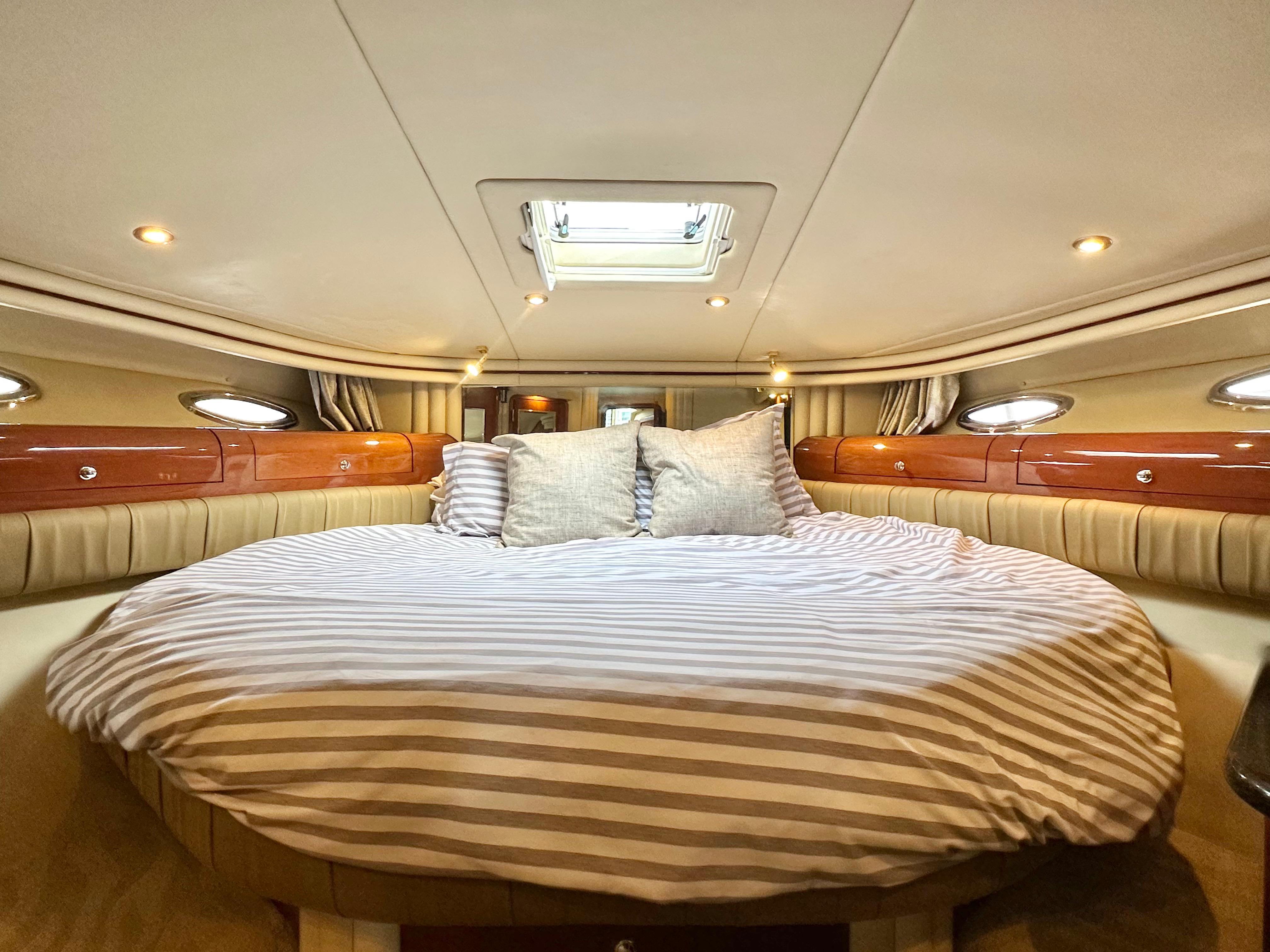 Luxurious cabin interior of 2002 Sea Ray 560 Sedan Bridge yacht with striped bedding.
